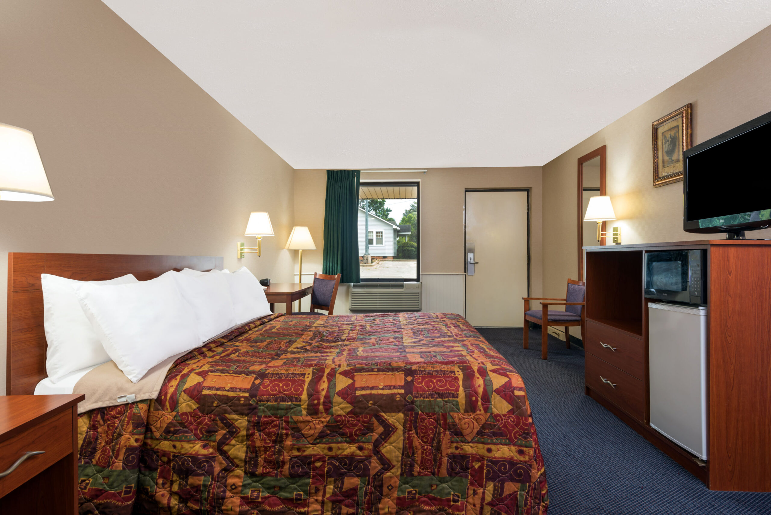Hotel room with a king bed and a seating area.