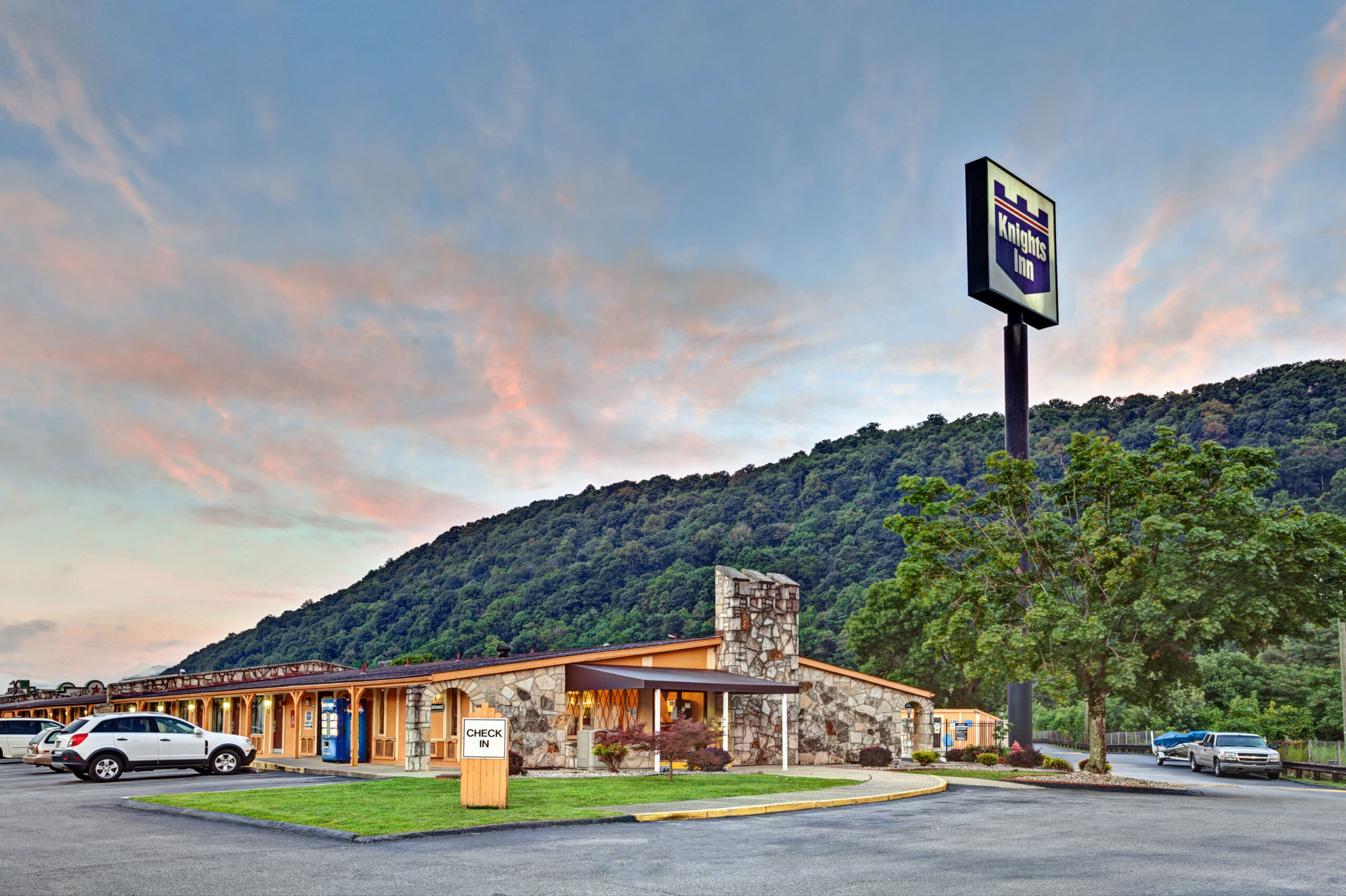 Exterior of motel at sunset with mountain background.