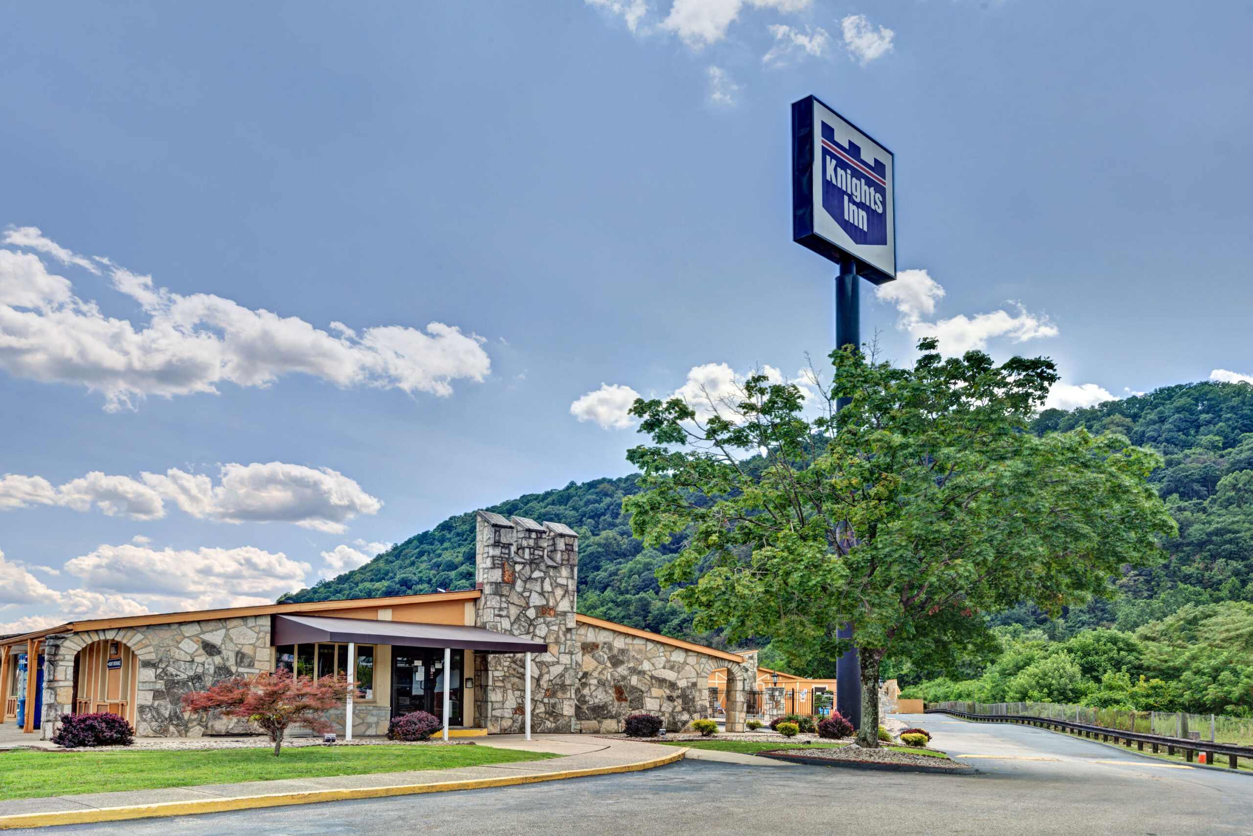 Exterior of motel at sunset with mountain background.