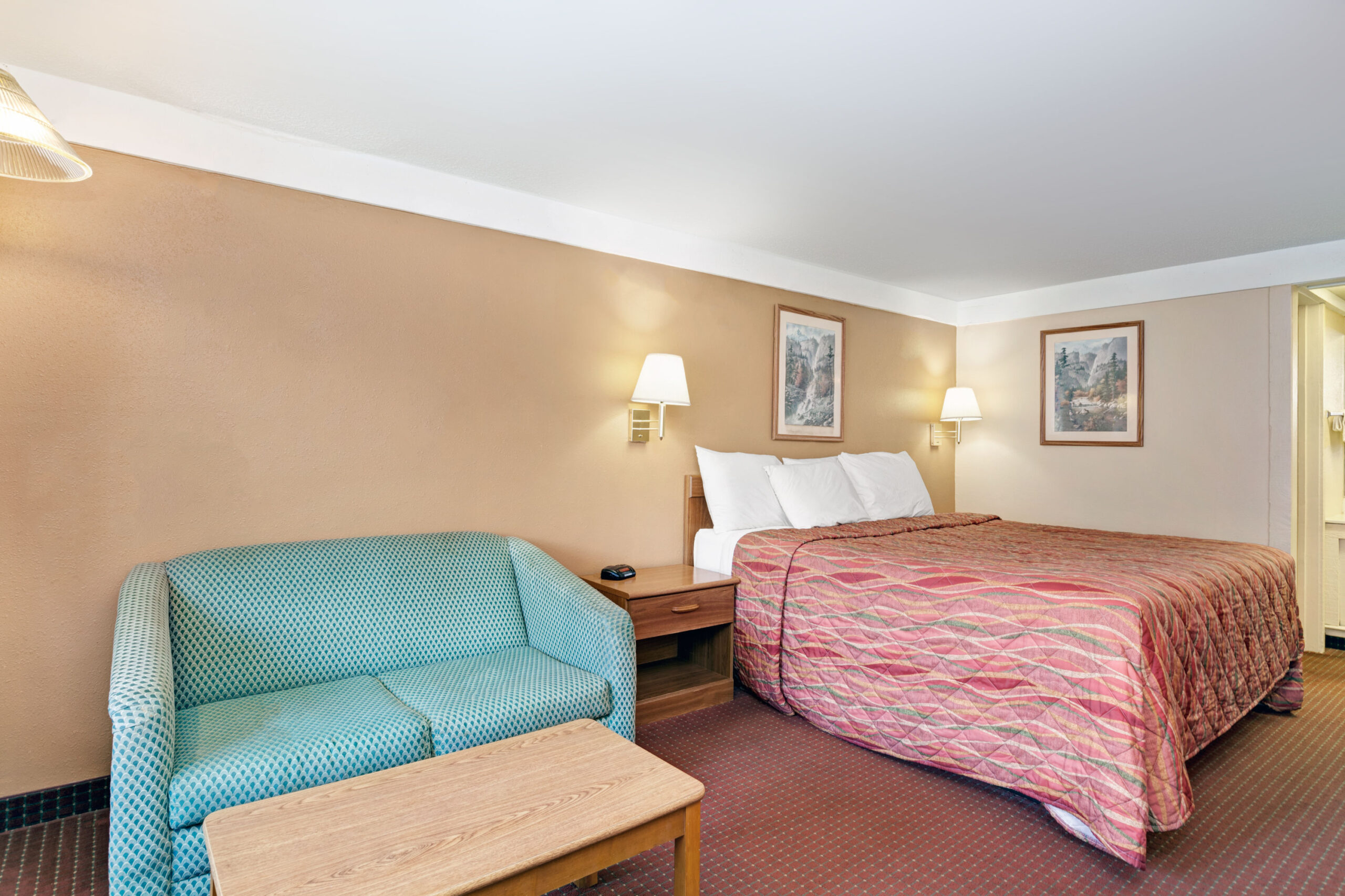 Hotel room with king bed and seating area.