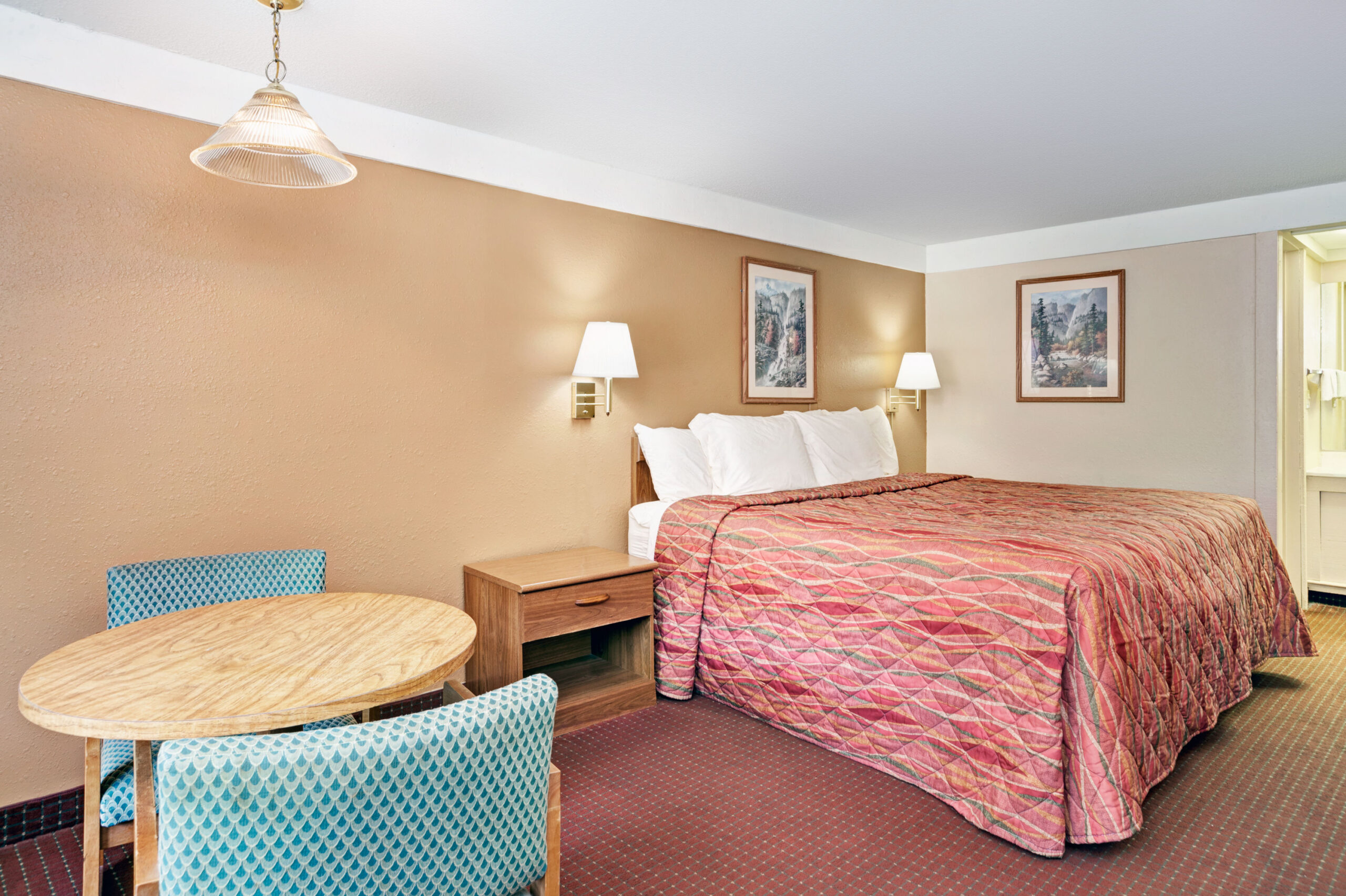 Hotel room with king bed and dining table.