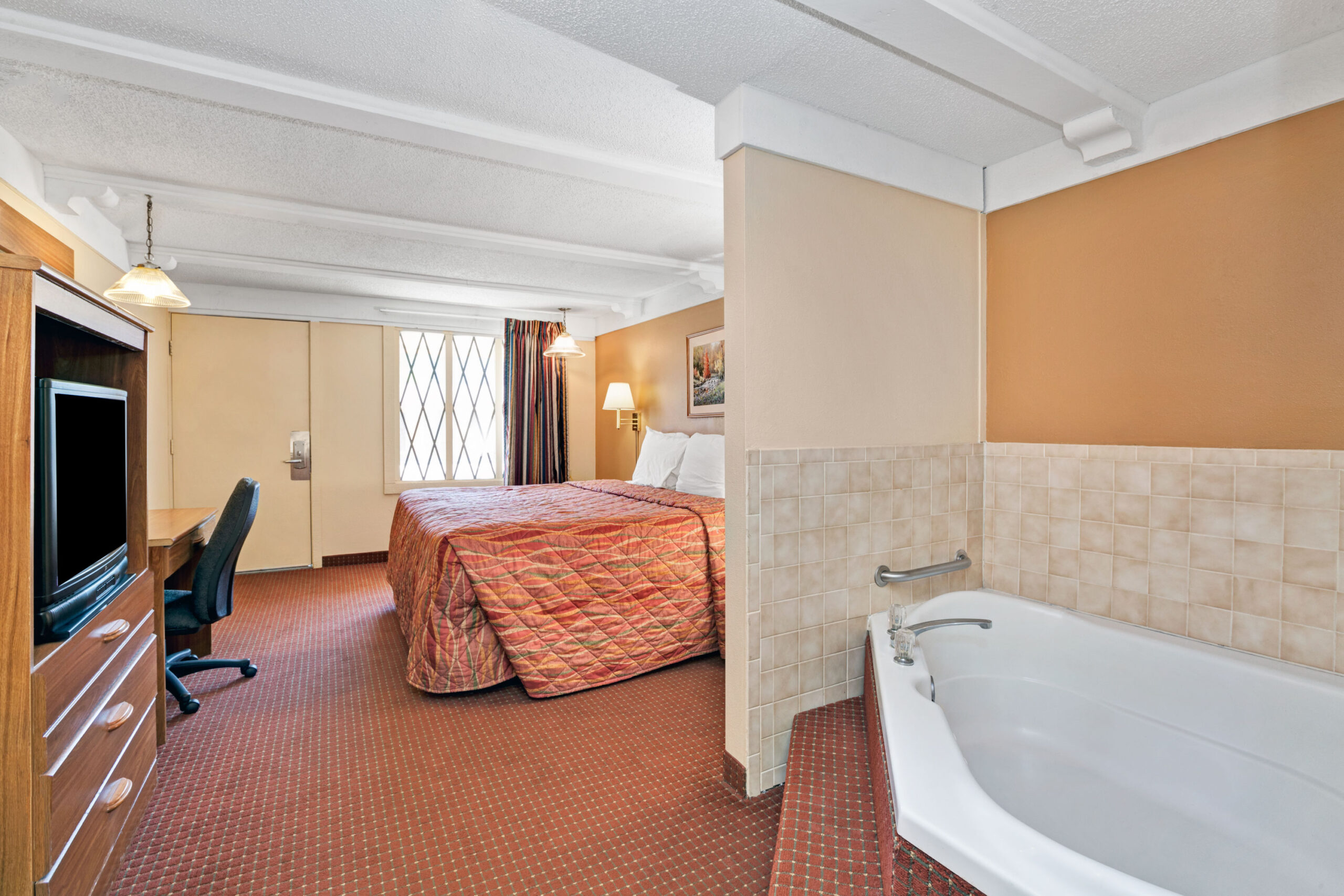 Hotel room with king bed and in-room bathtub.