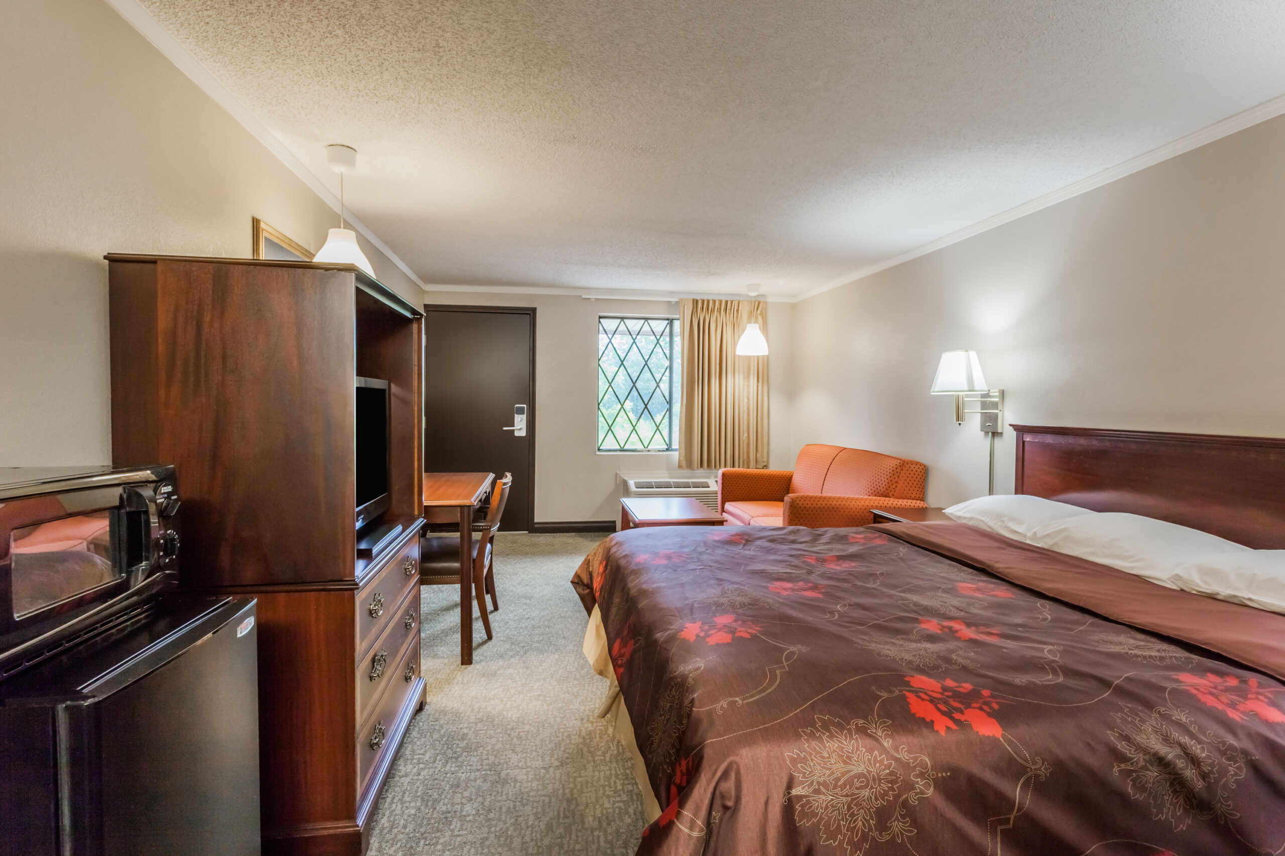 Hotel room with a double bed with a seating area.