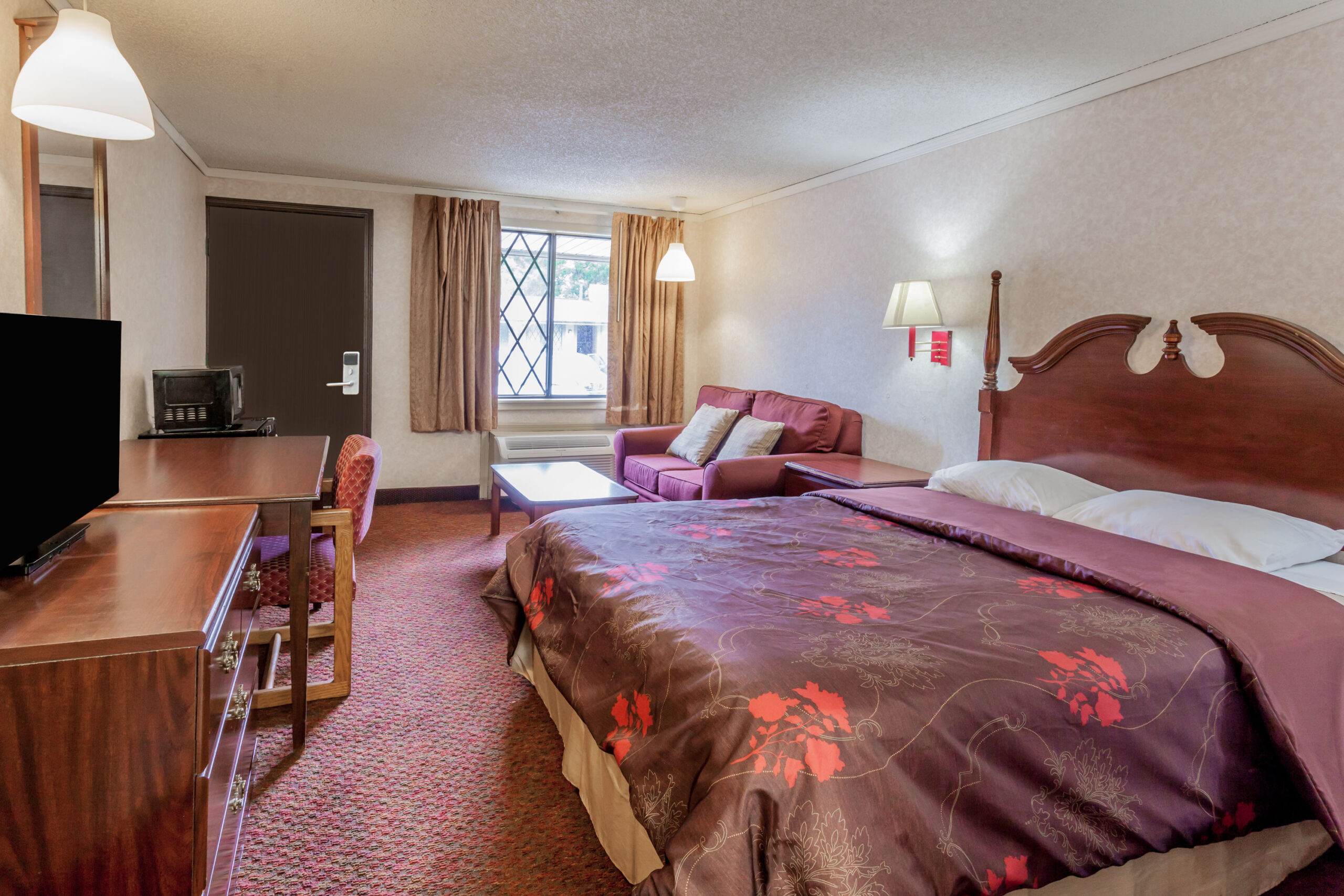 Hotel room with a double bed with a seating area.