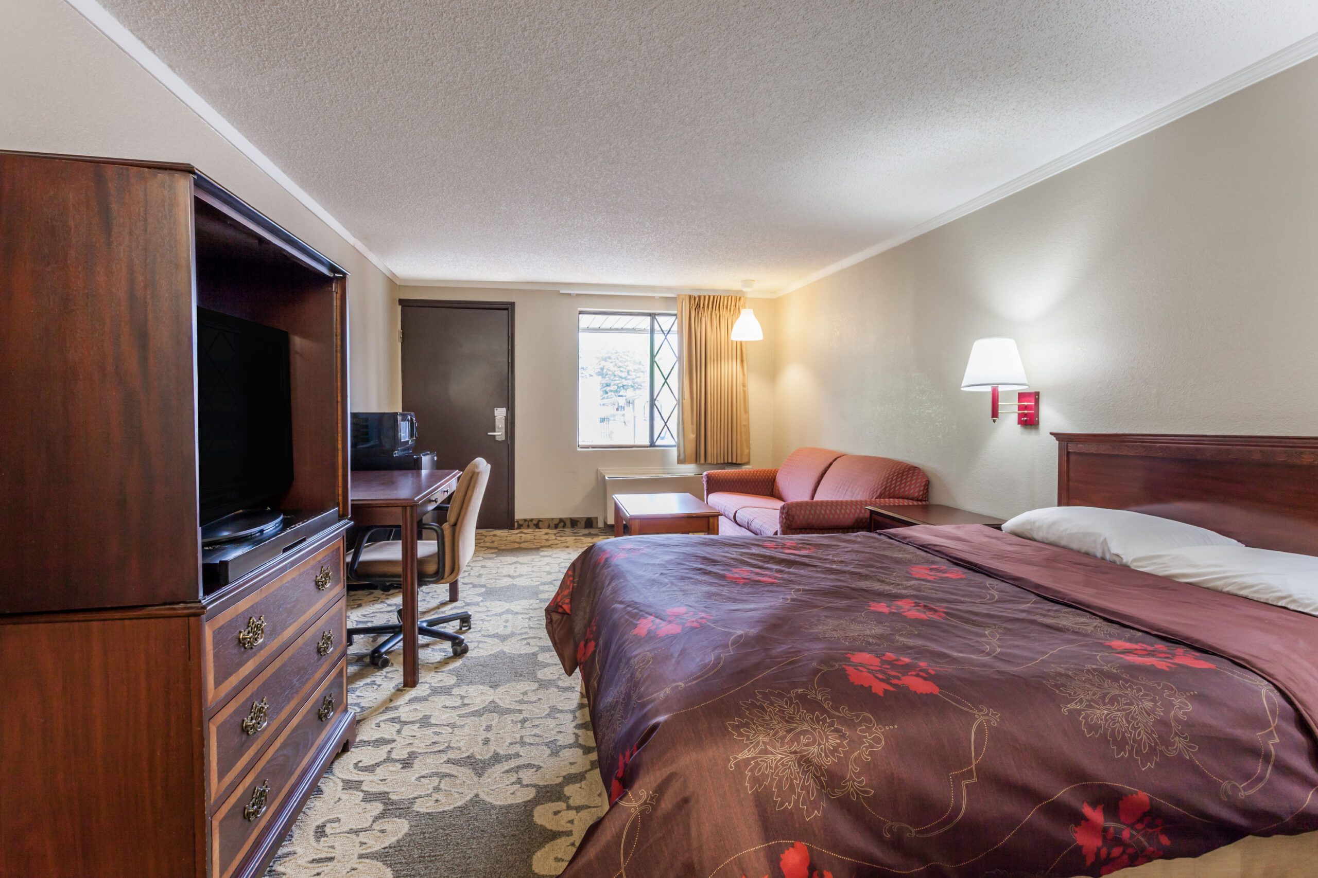 Hotel room with a double bed with a seating area.