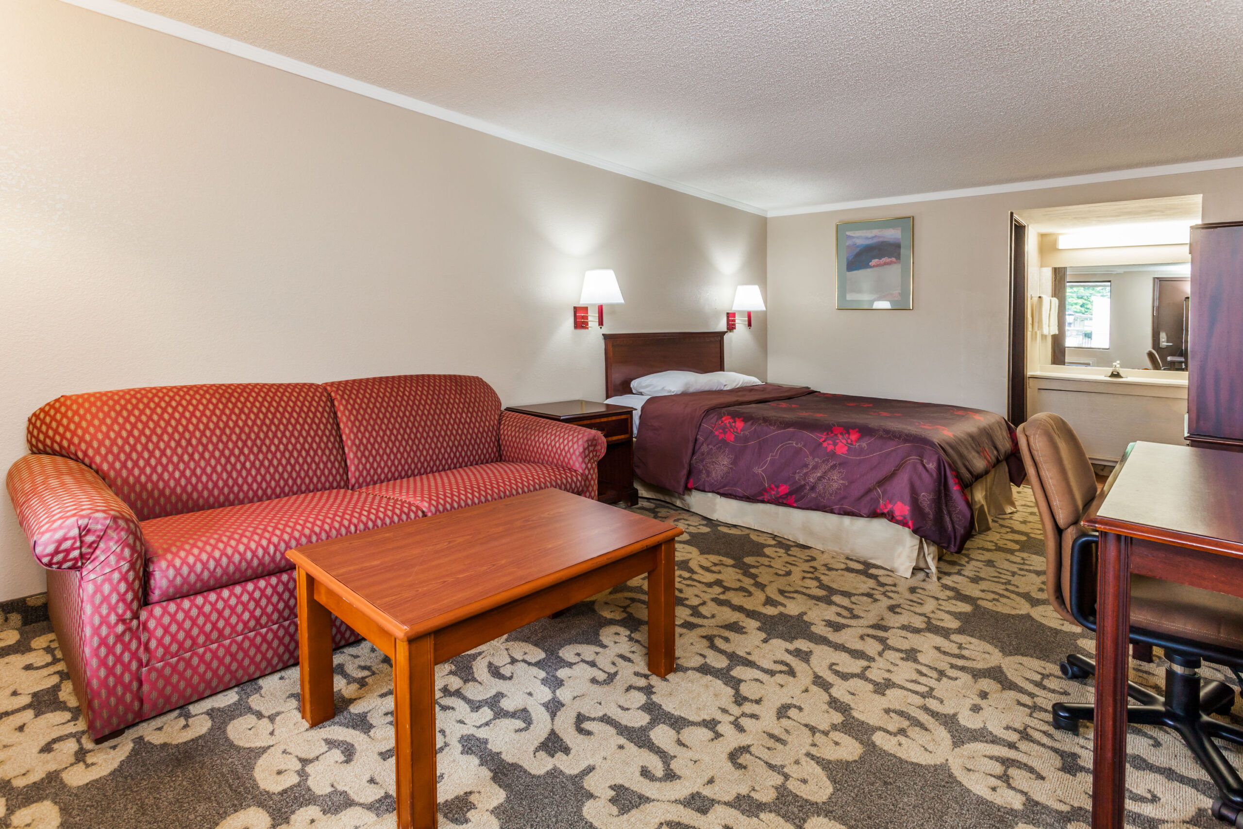 Hotel room with a double bed with a seating area.