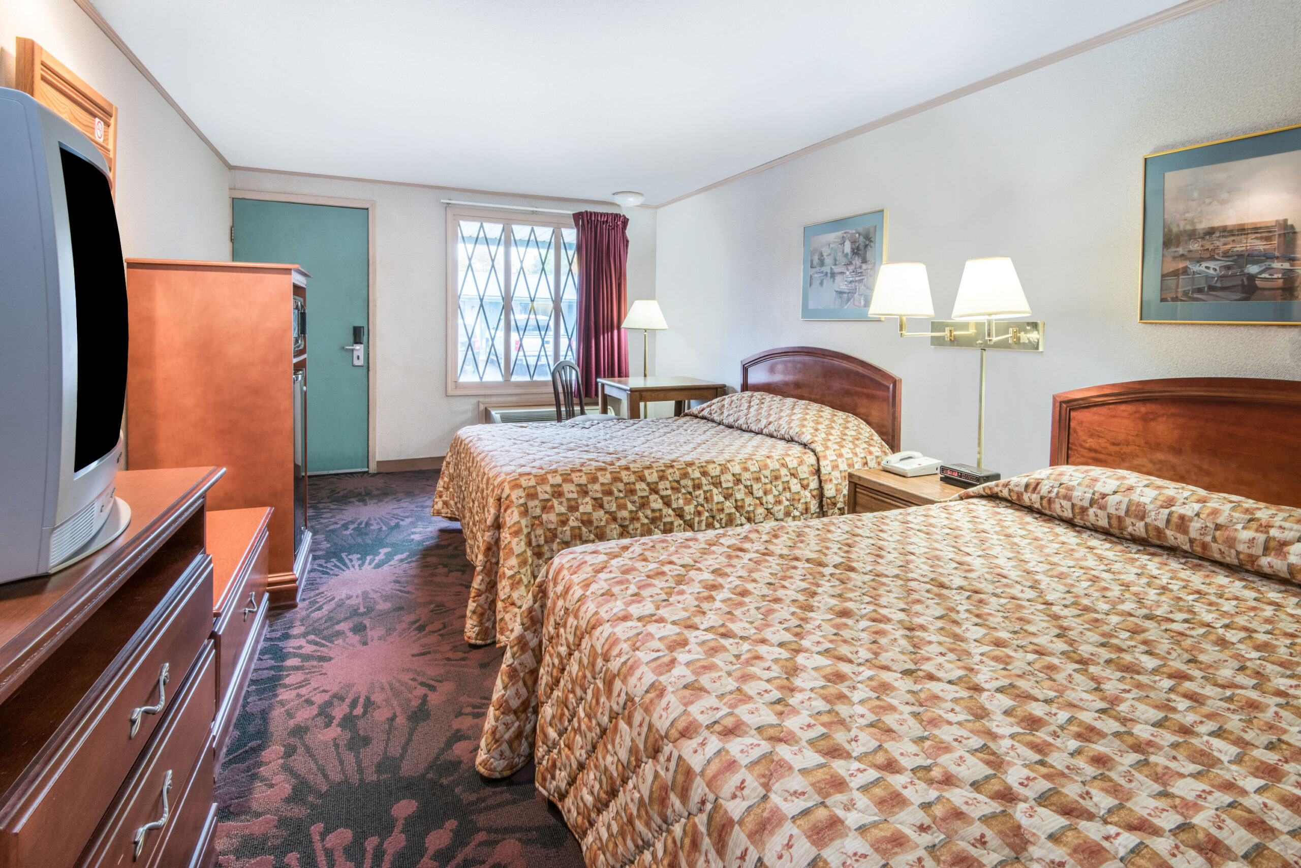 Hotel room with two double beds and a seating area.