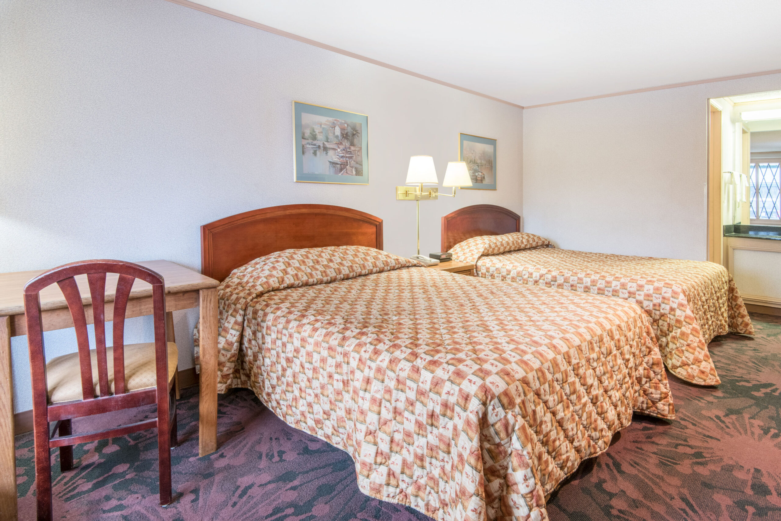 Hotel room with two double beds and a seating area.
