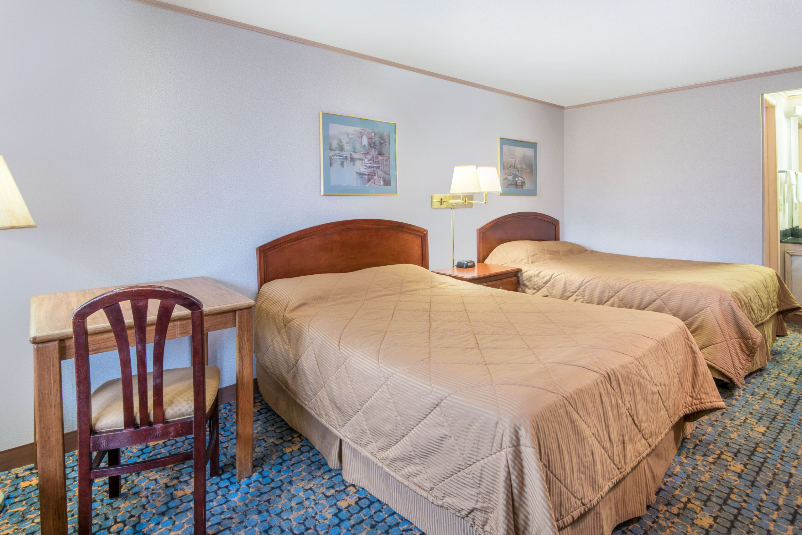 Hotel room with two double beds and a seating area.