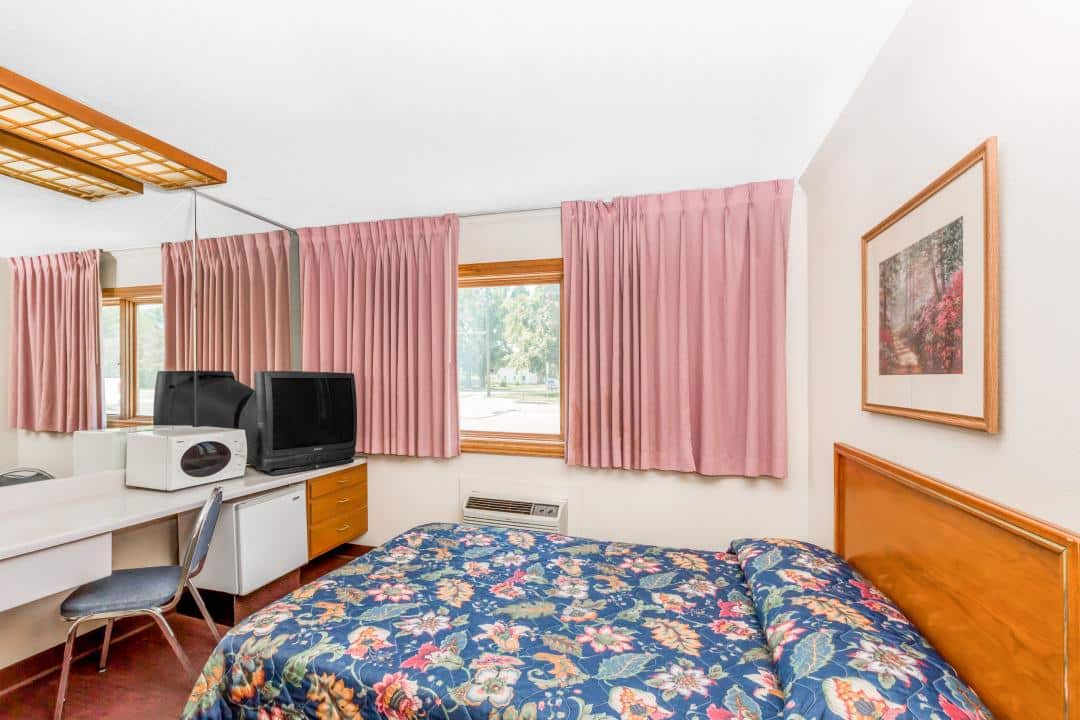 Hotel room with a bed and TV.