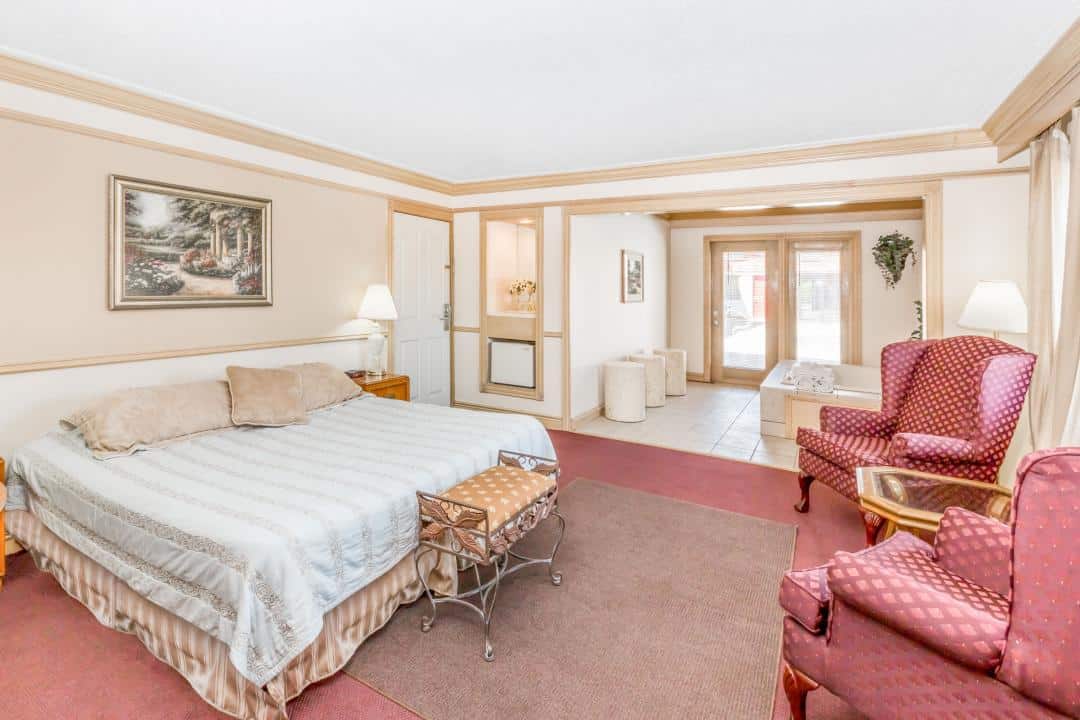 Hotel room with a king bed and a seating area.