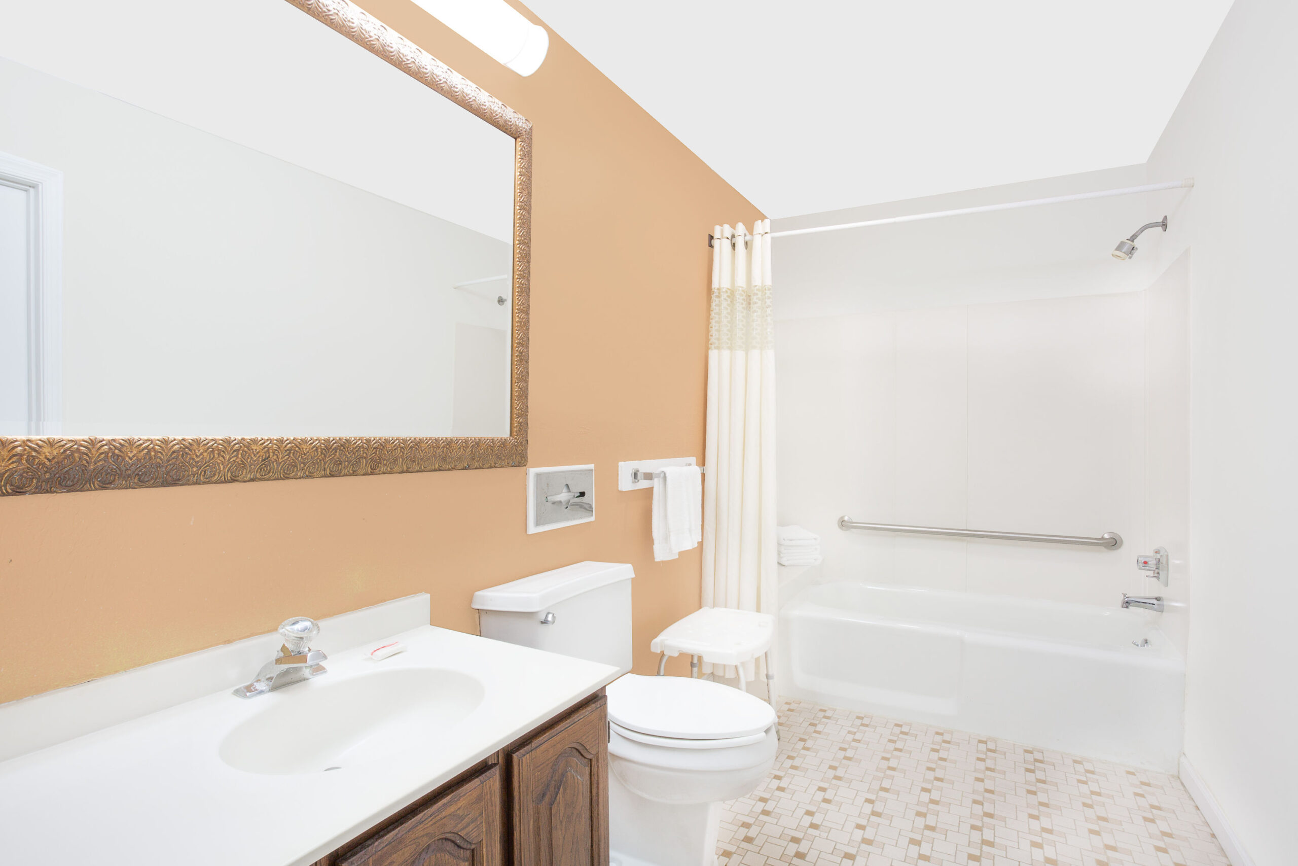 Bathroom with vanity, toilet, and bathtub with grab bar.