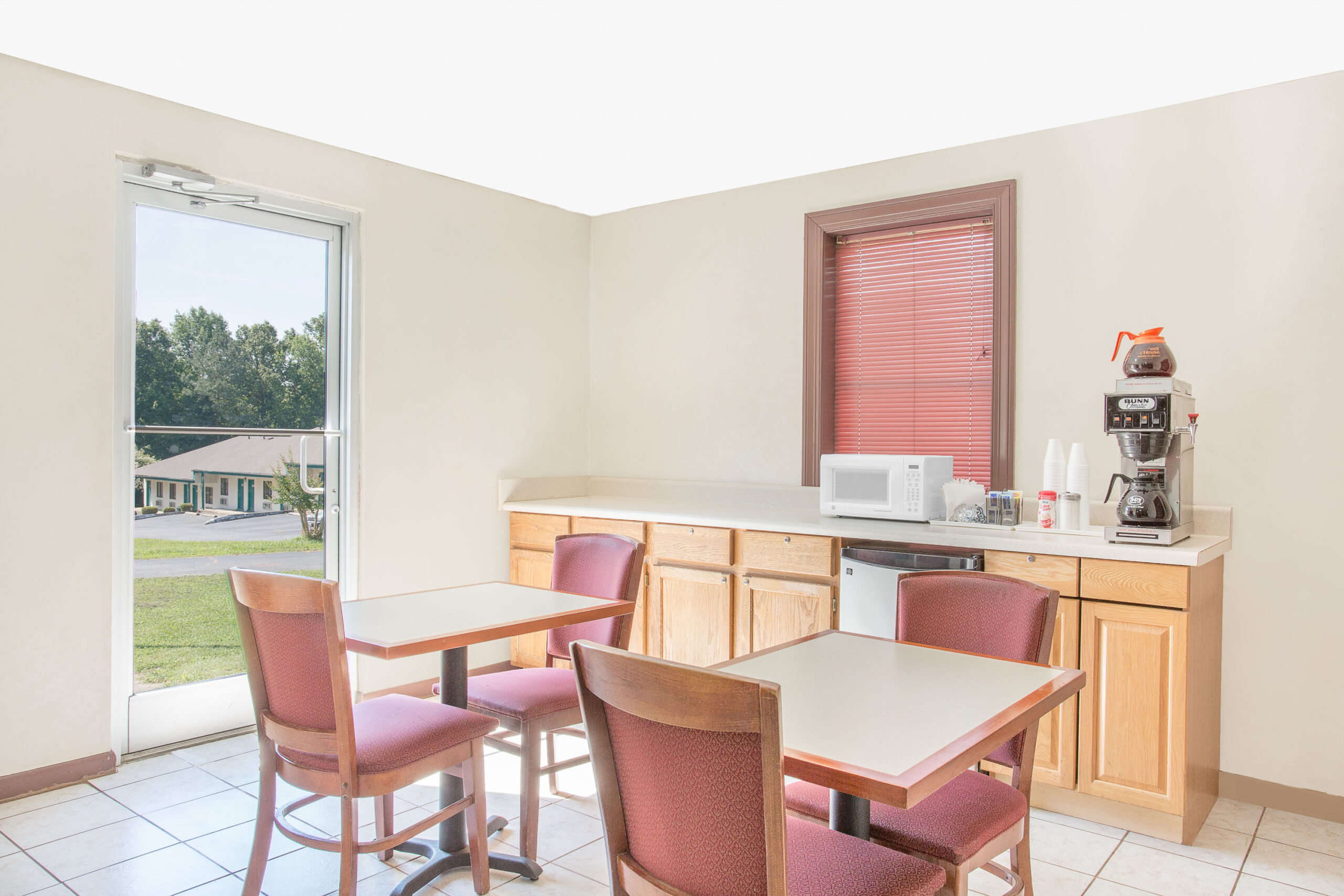 Small breakfast area with tables, chairs, and coffee machine.