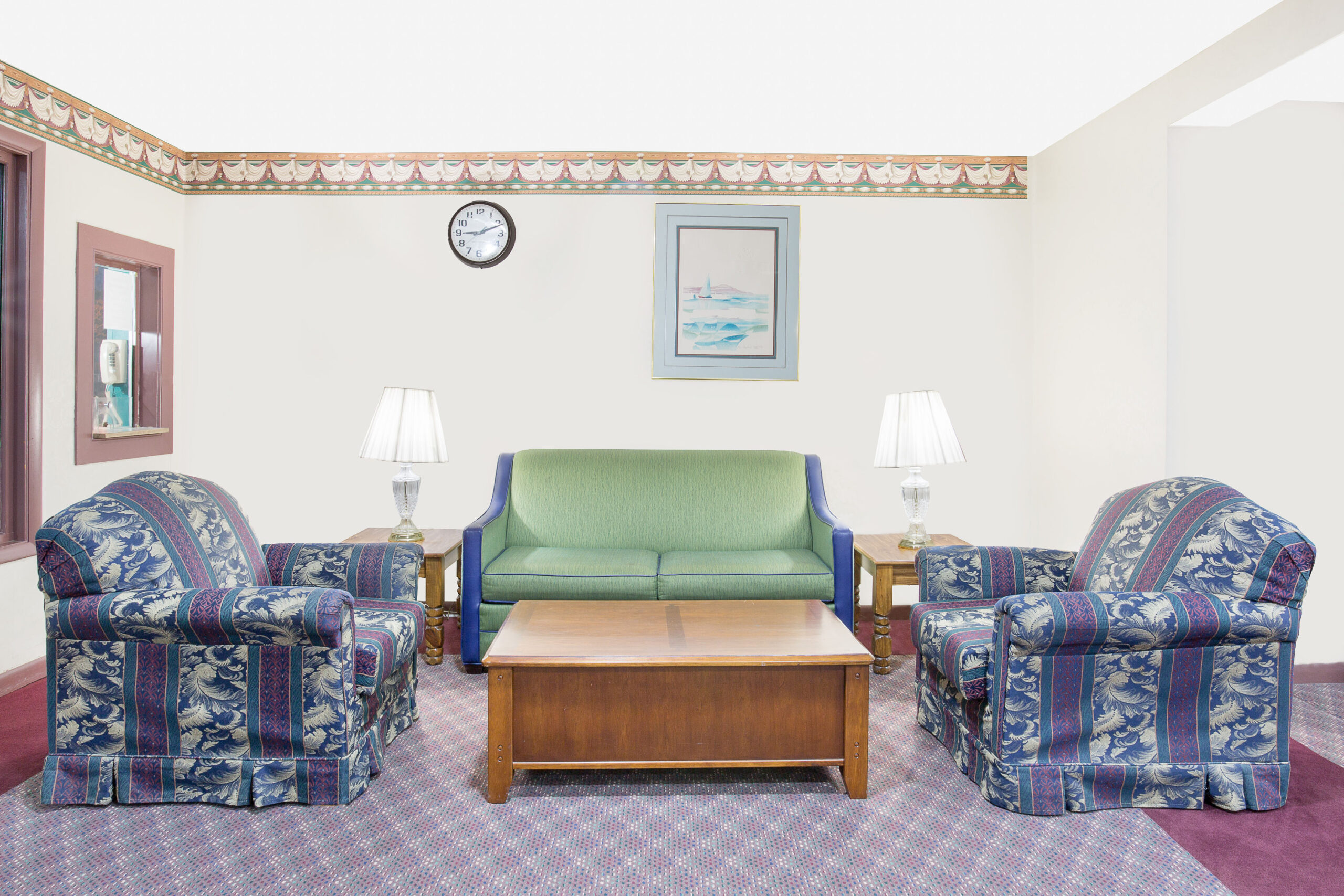 Cozy seating area in hotel lobby with chairs and sofa.
