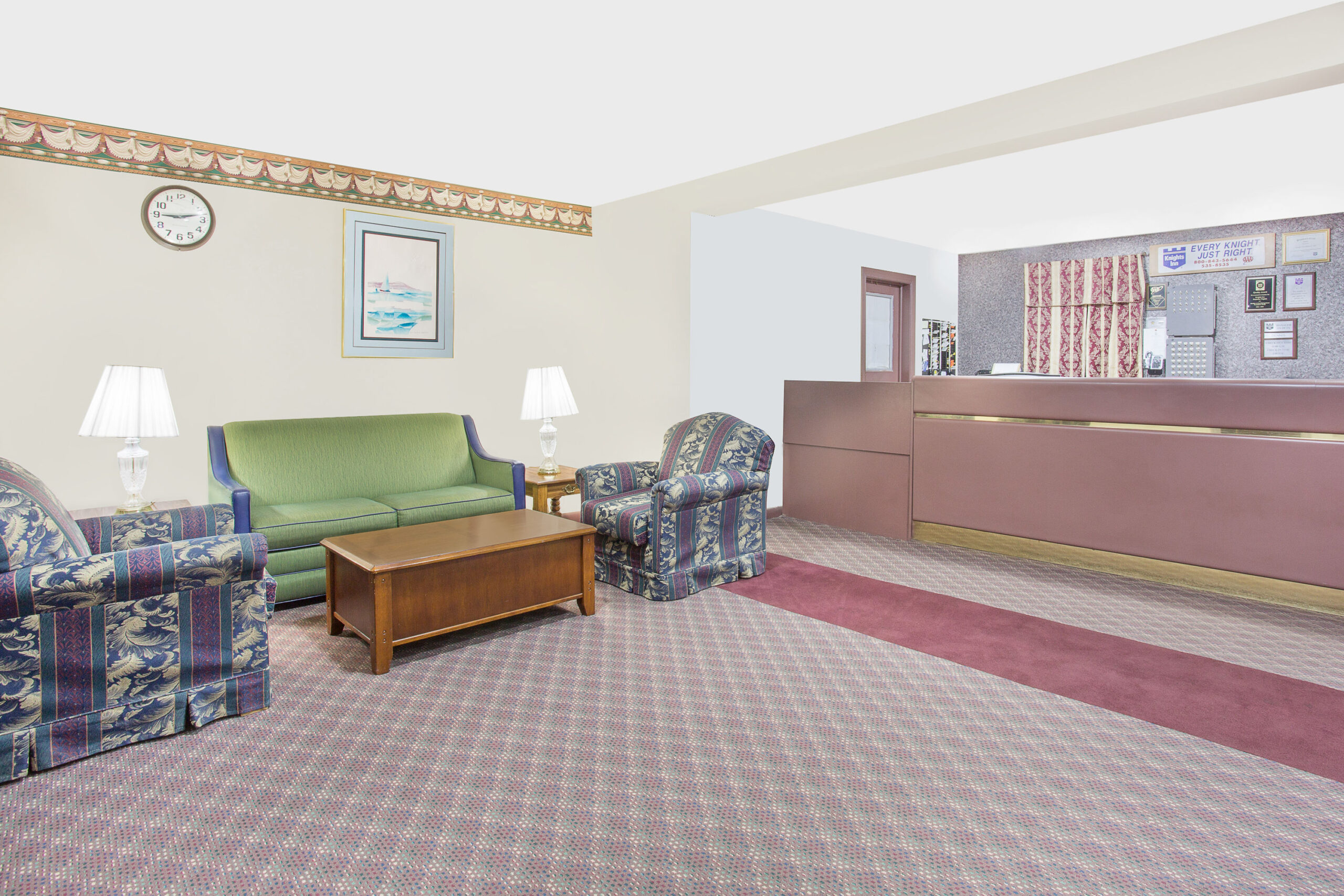 Hotel lobby with seating area and reception desk.