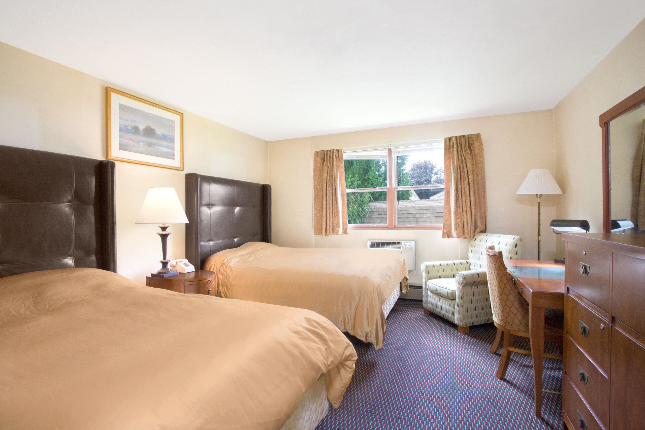 Hotel room with two double beds with a seating area.