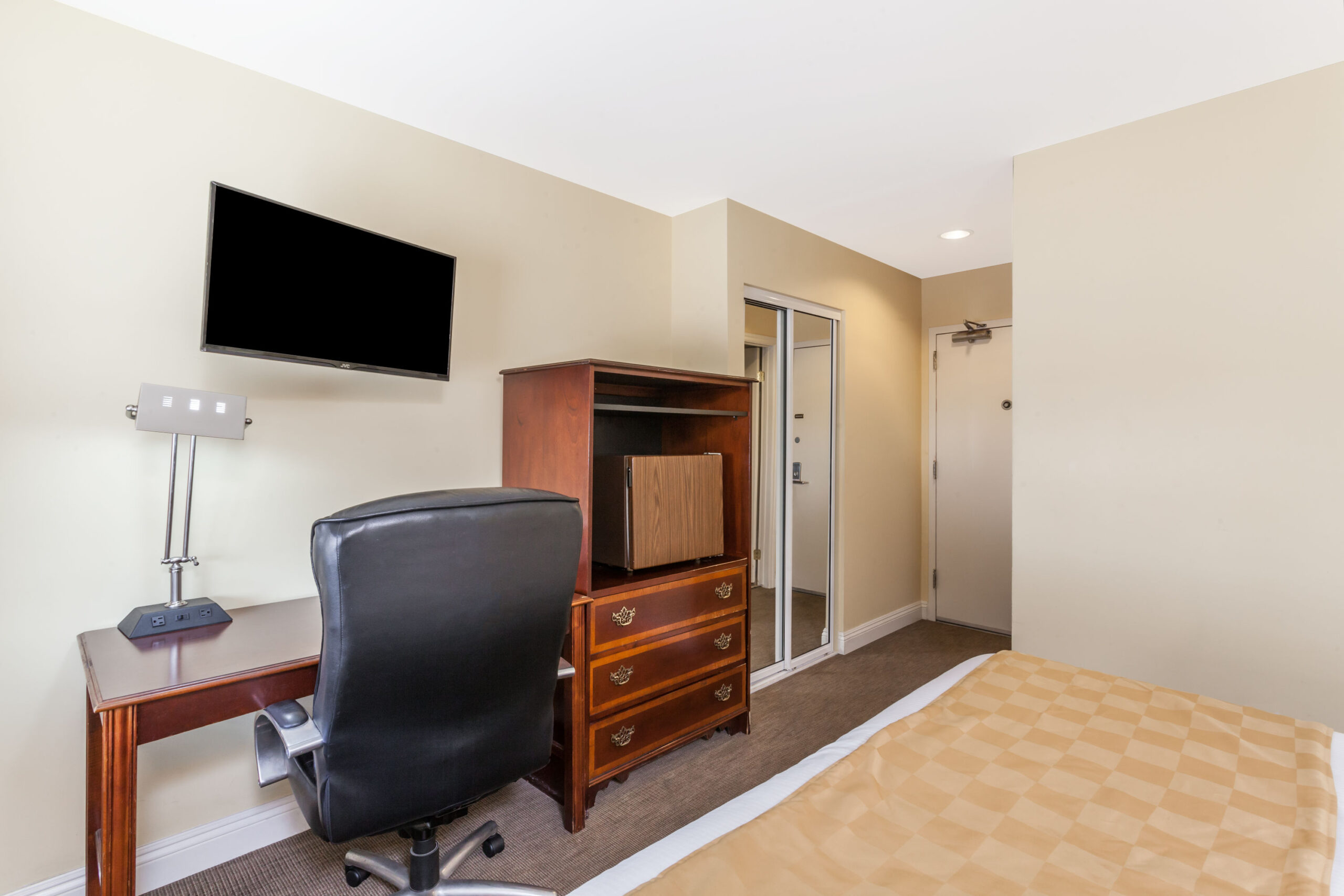 Hotel room with work area and TV.