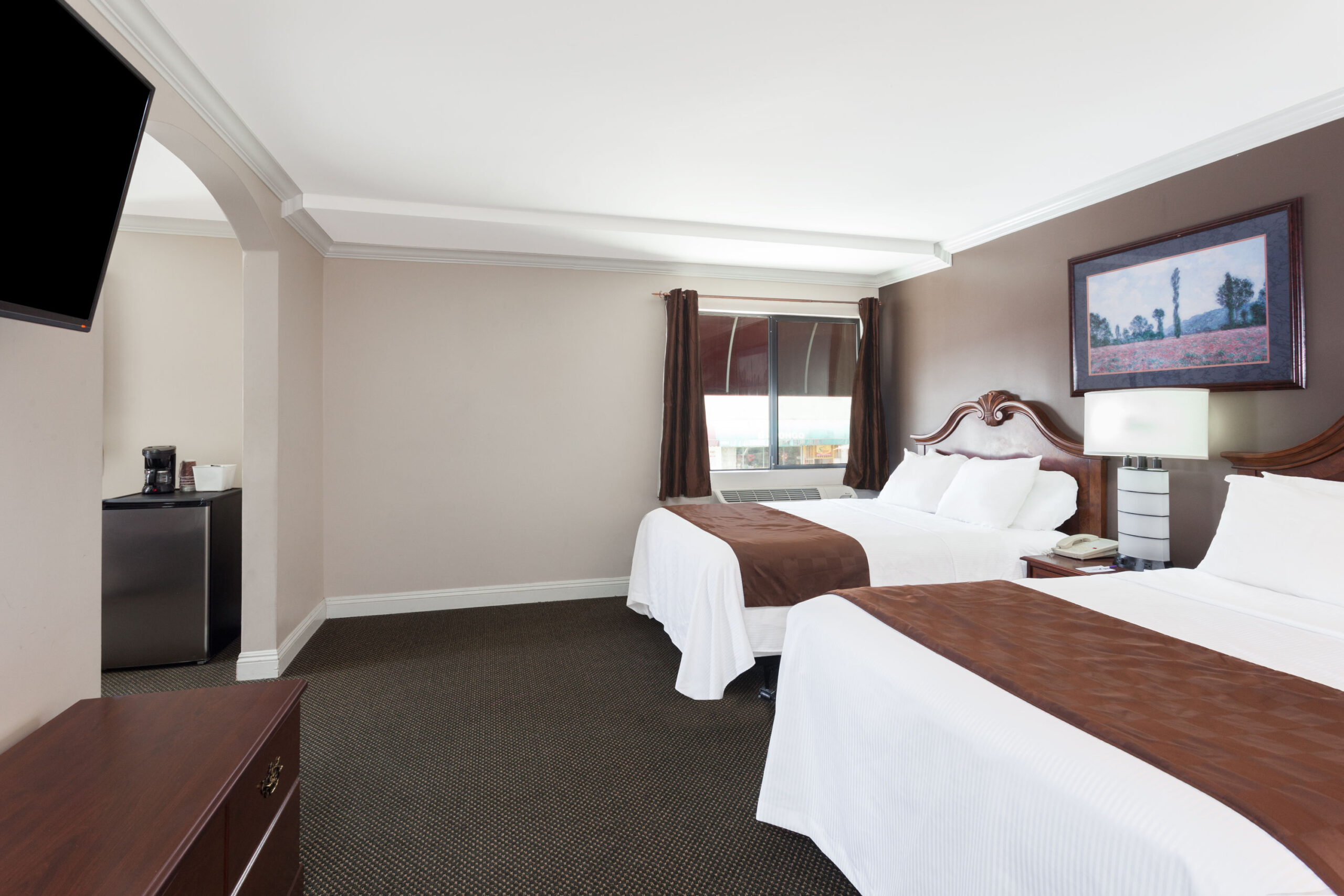 Hotel room with two double beds and a TV.