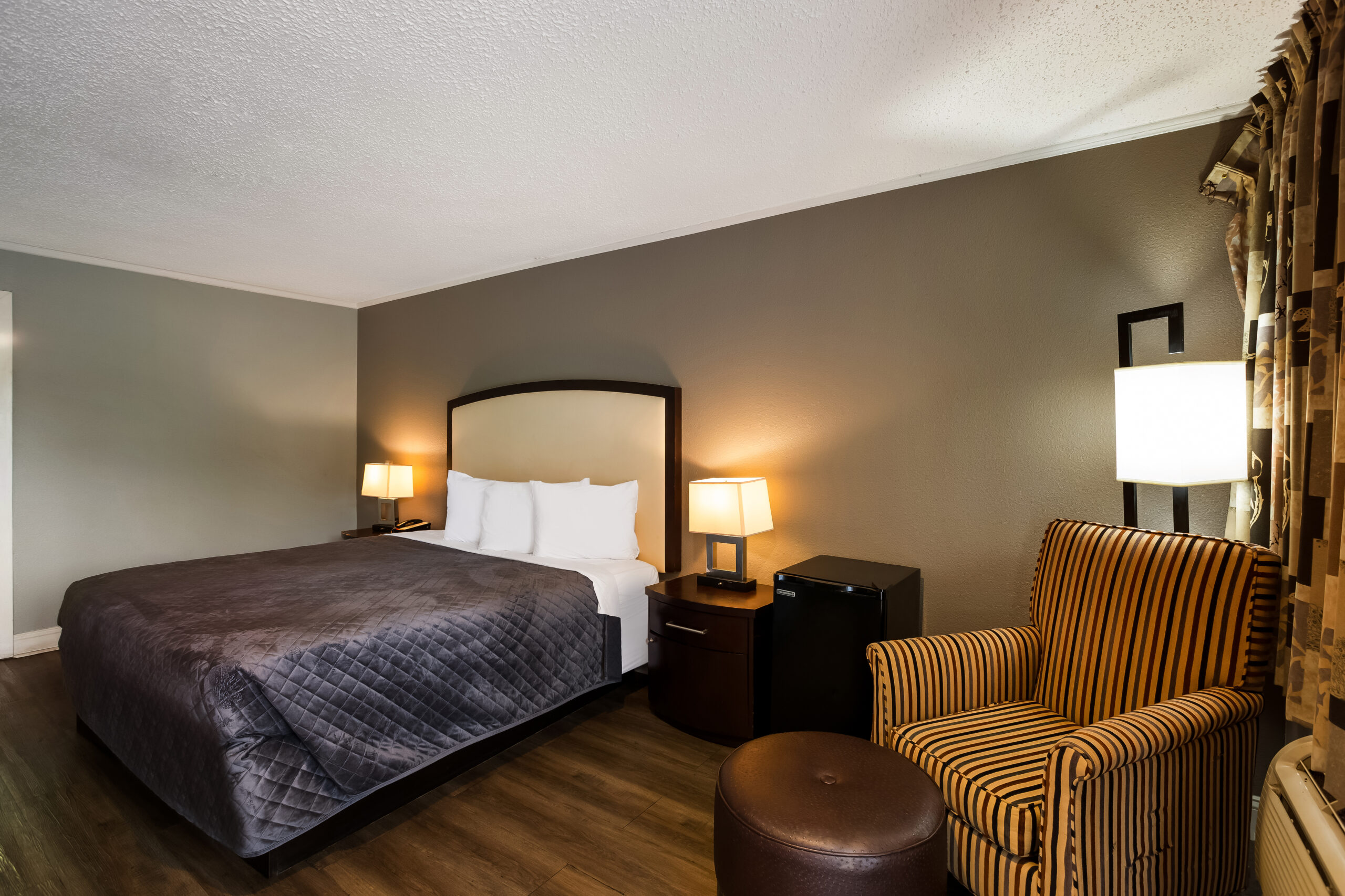 Hotel room with a king bed and a seating area.