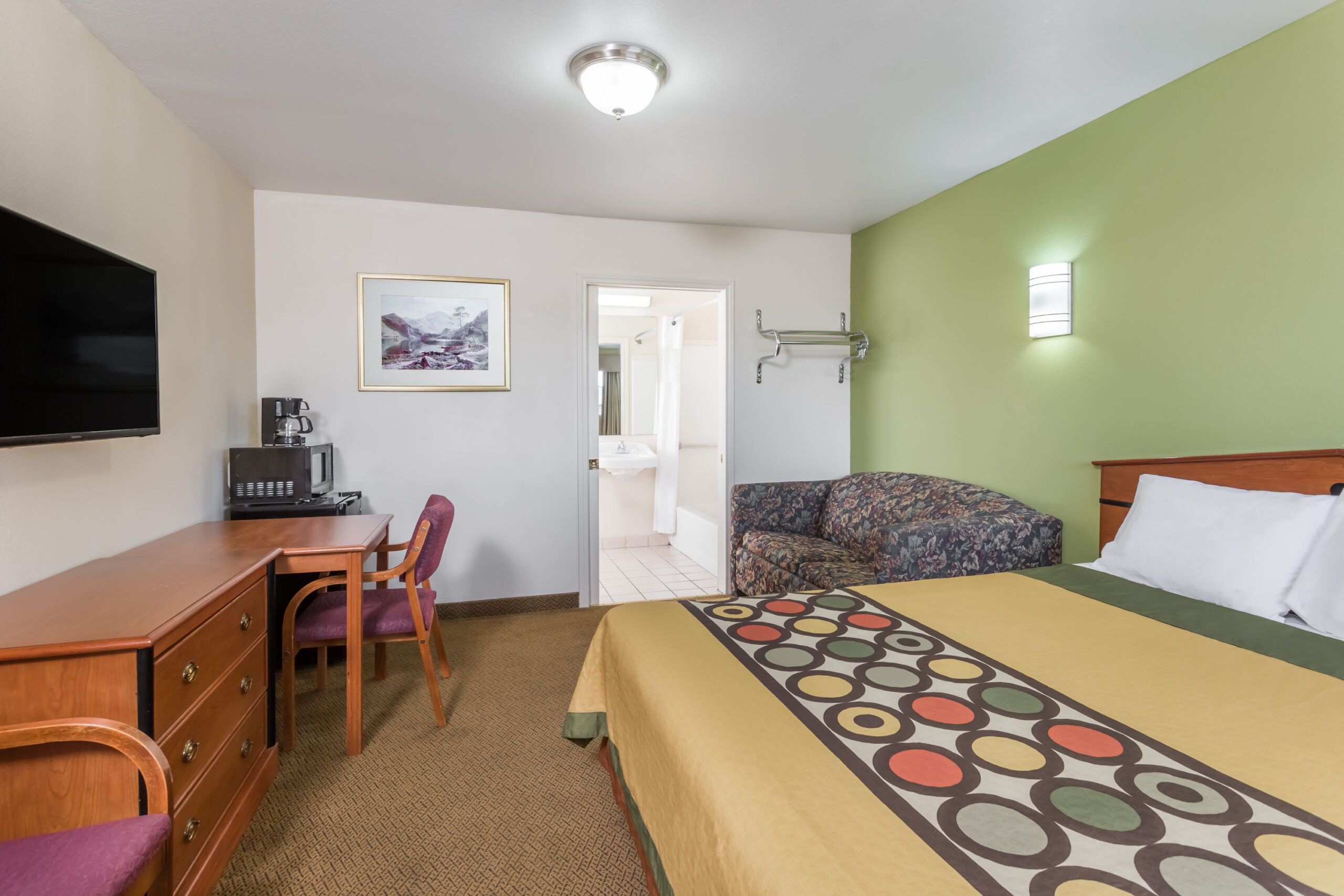 Hotel room with a double bed and a work area.