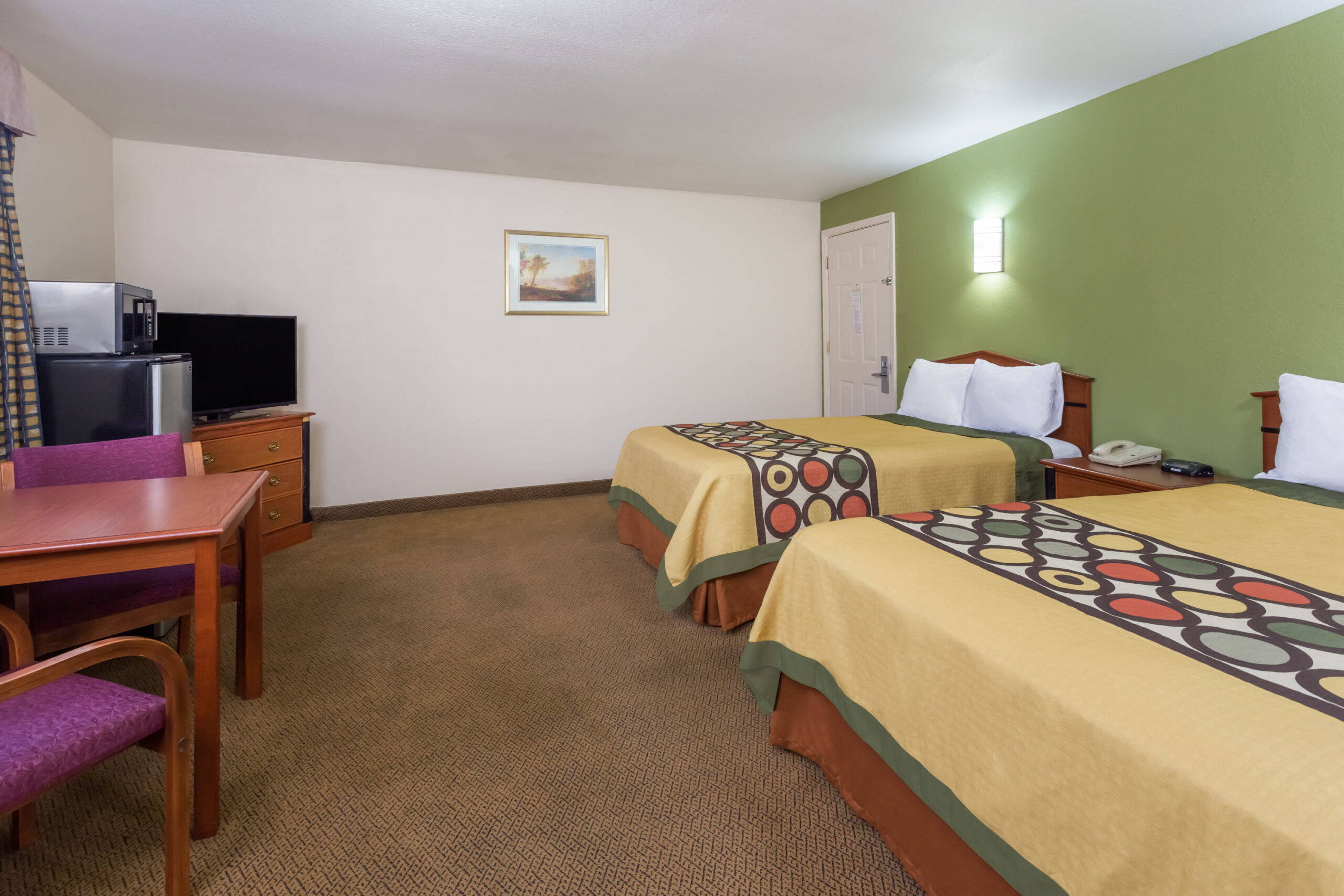 Hotel room with two beds and a work area.