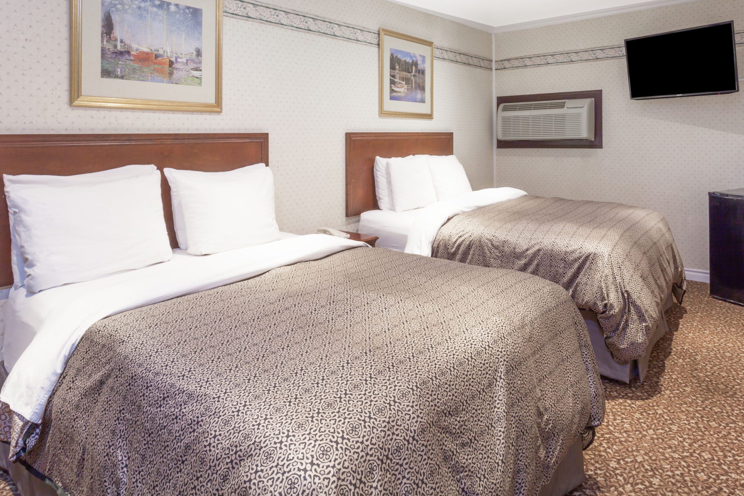 Two beds with brown bedding.