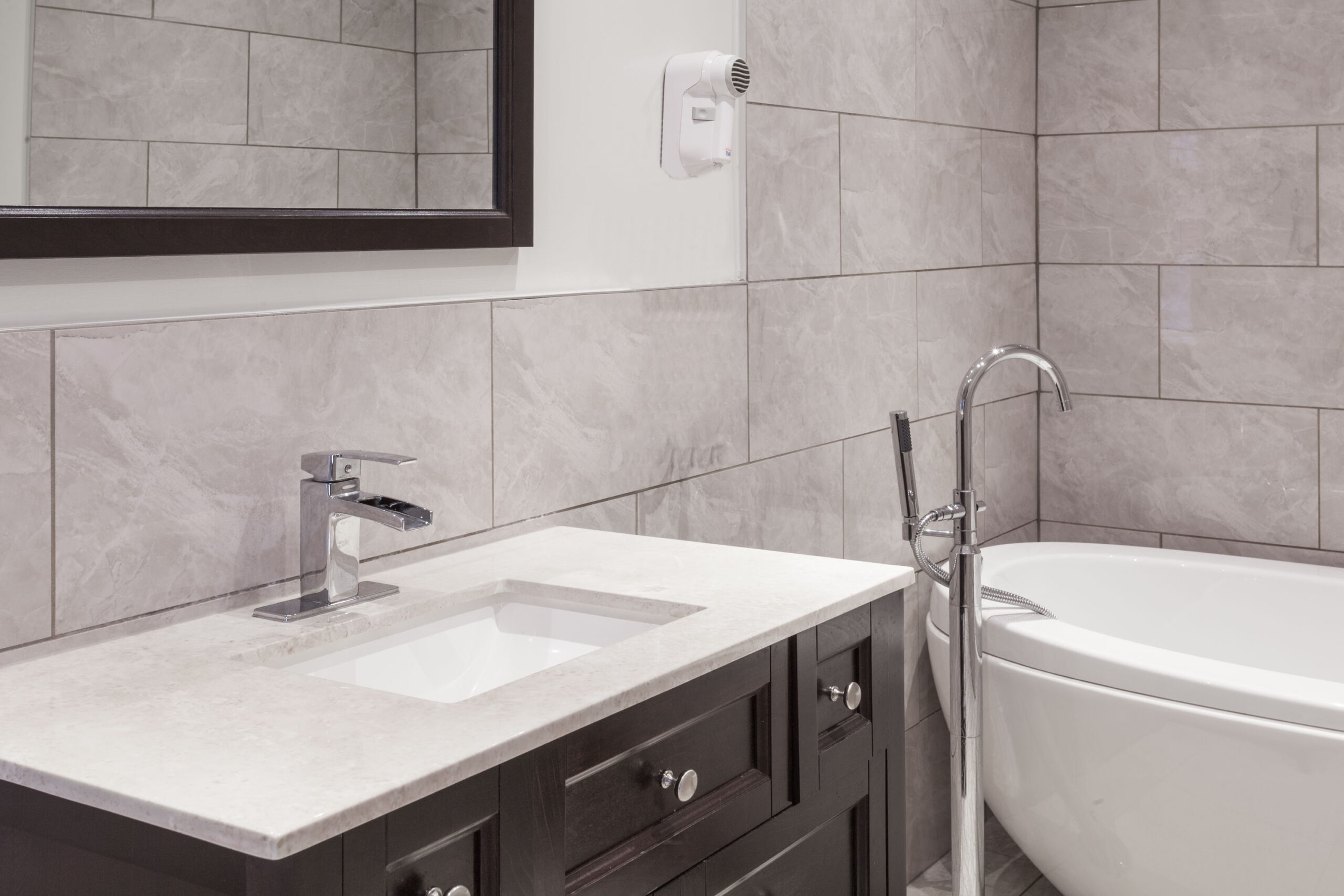 A motel room with a king-sized bed, a small dining table, and a view of the bathroom through an open door.