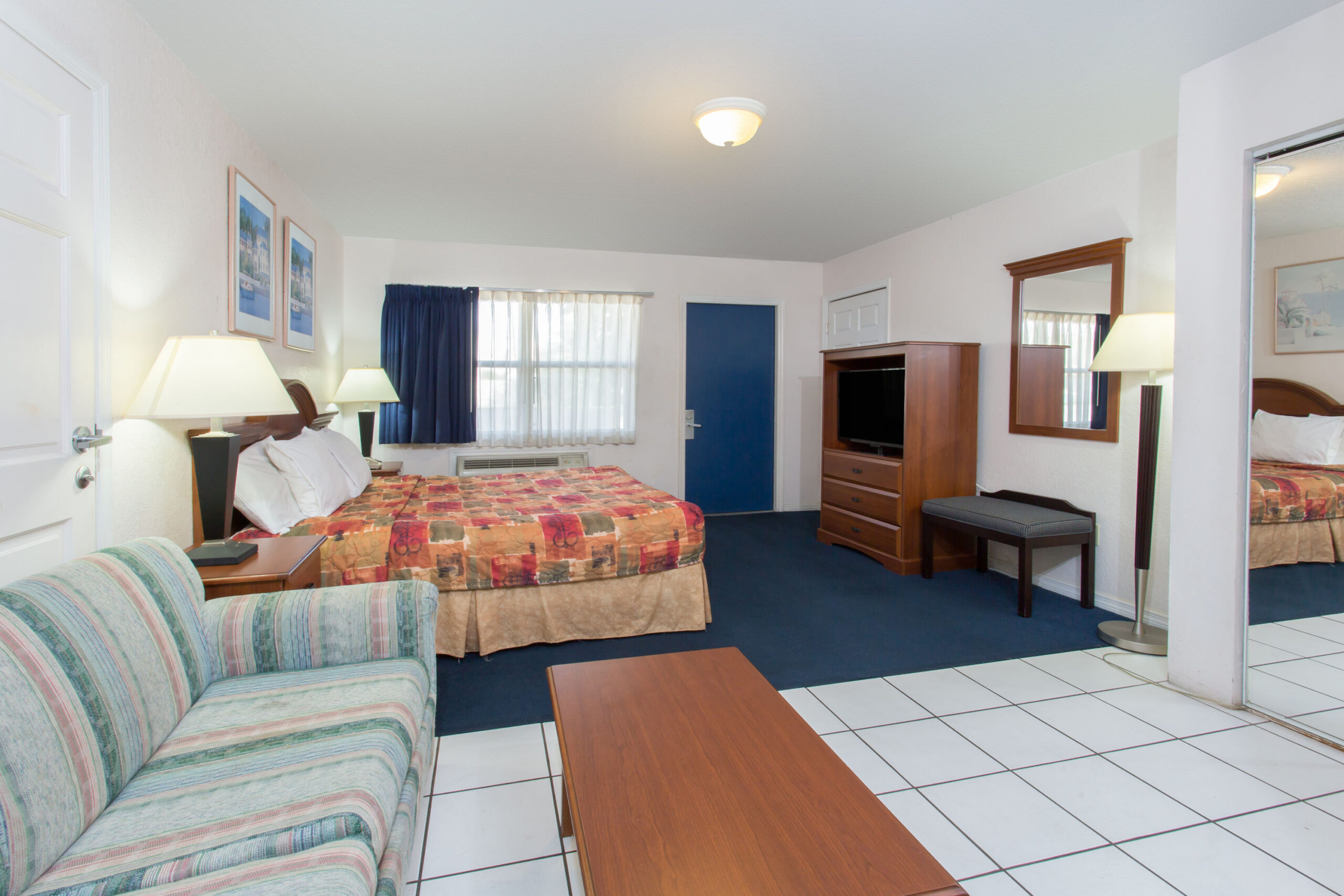 Hotel room with a double bed, seating area and a TV.