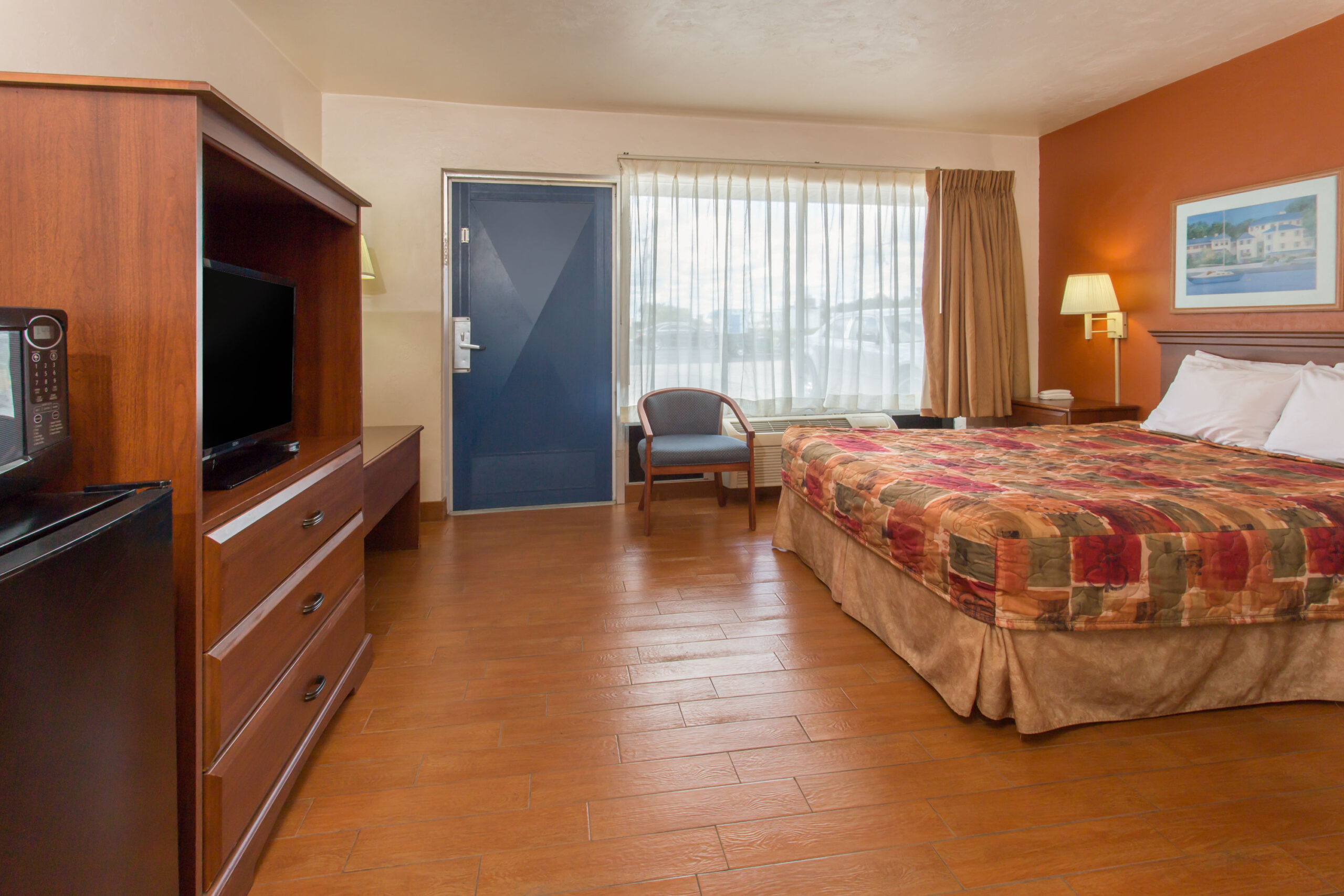 Hotel room with a double bed, seating area and a TV.