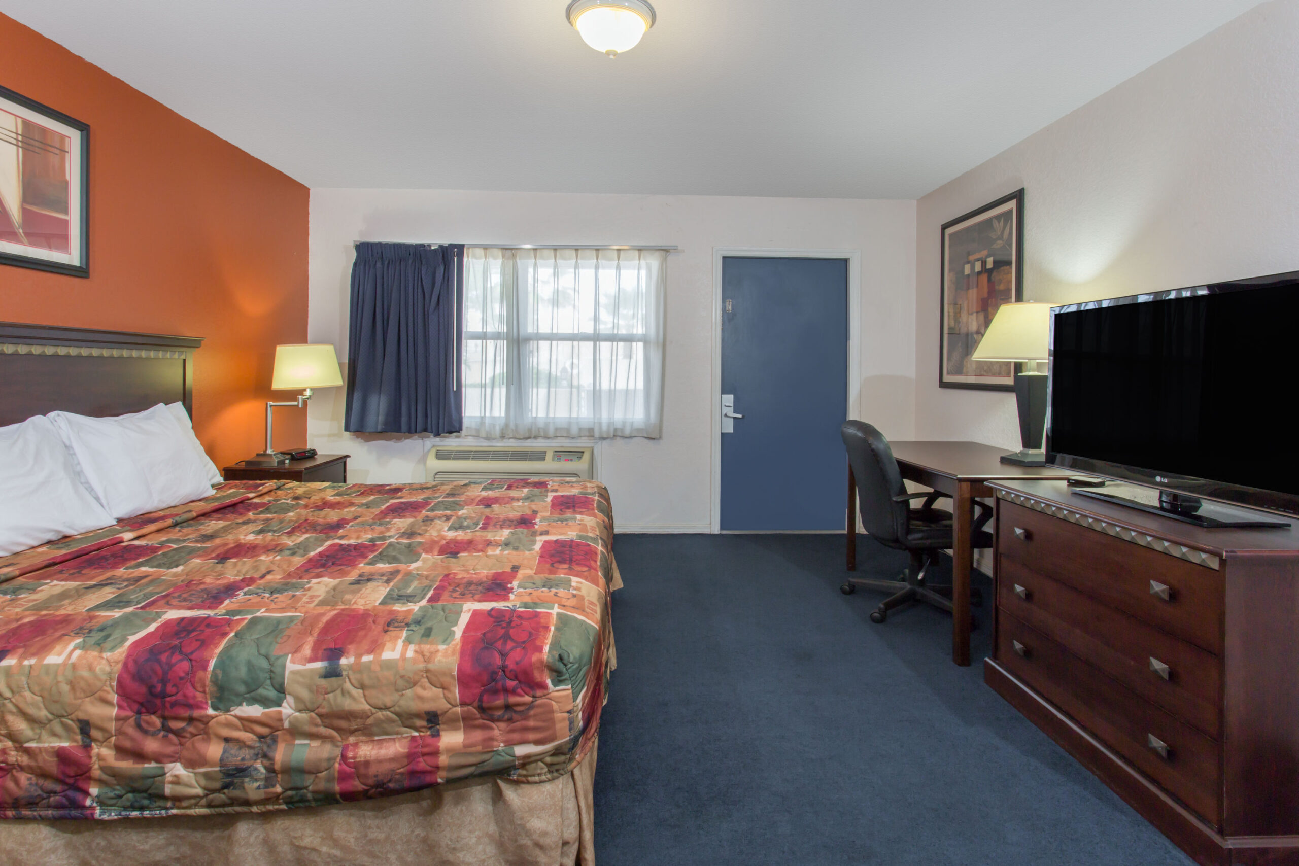 Hotel room with a double bed and a work area.
