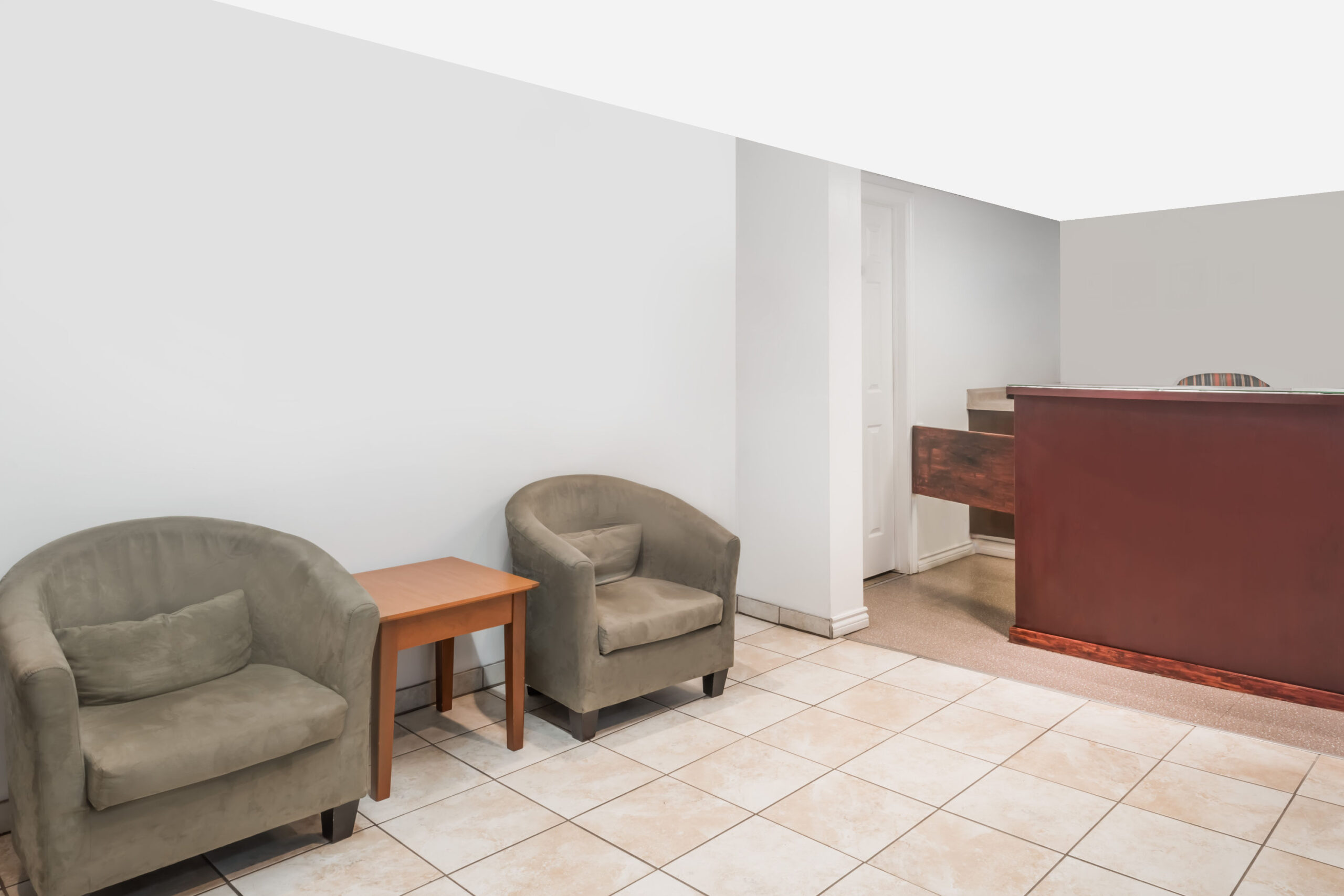 Small hotel lobby with armchairs and a front desk.