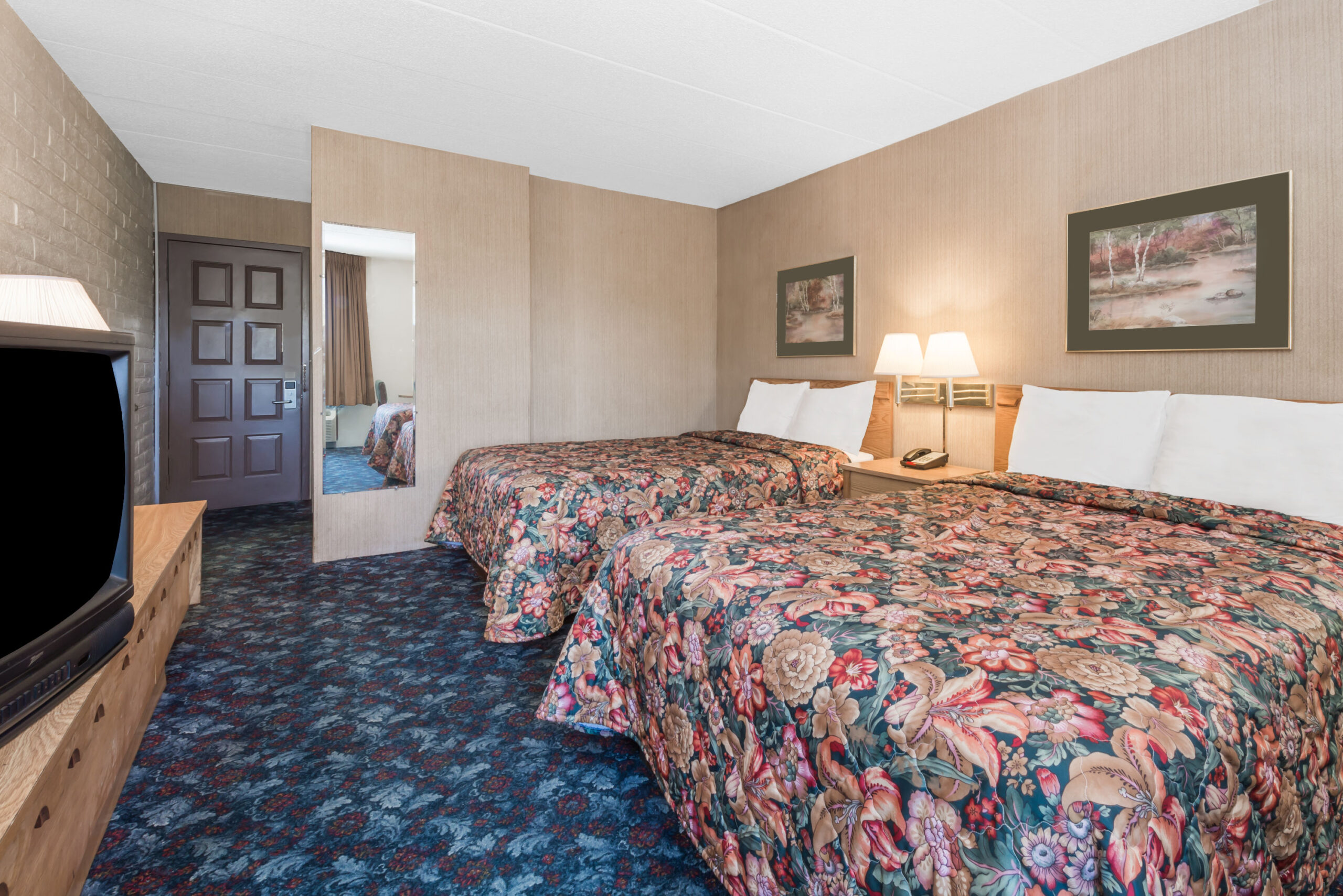 Hotel room with two double beds with a seating area.