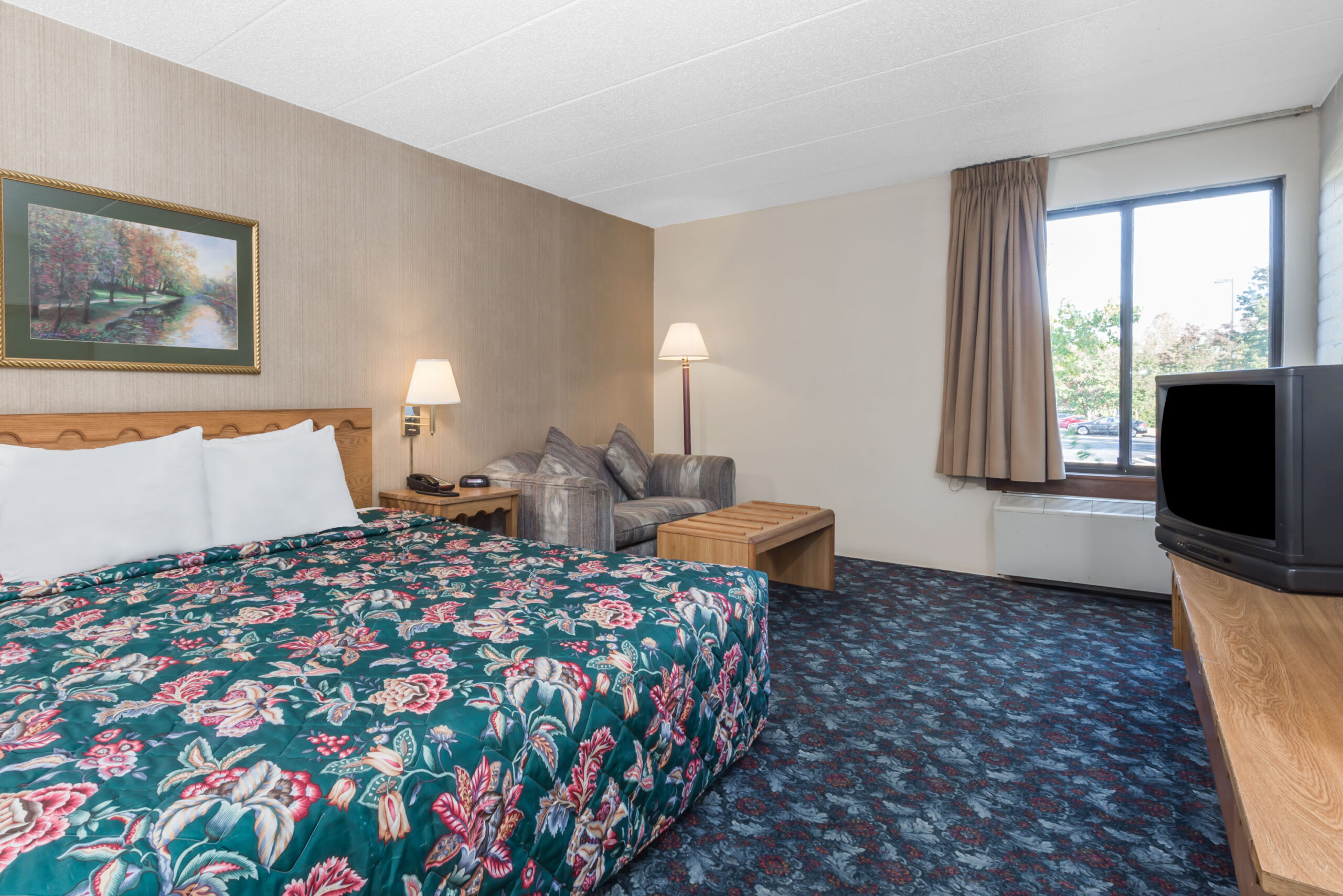 Hotel room with a king bed and a seating area.