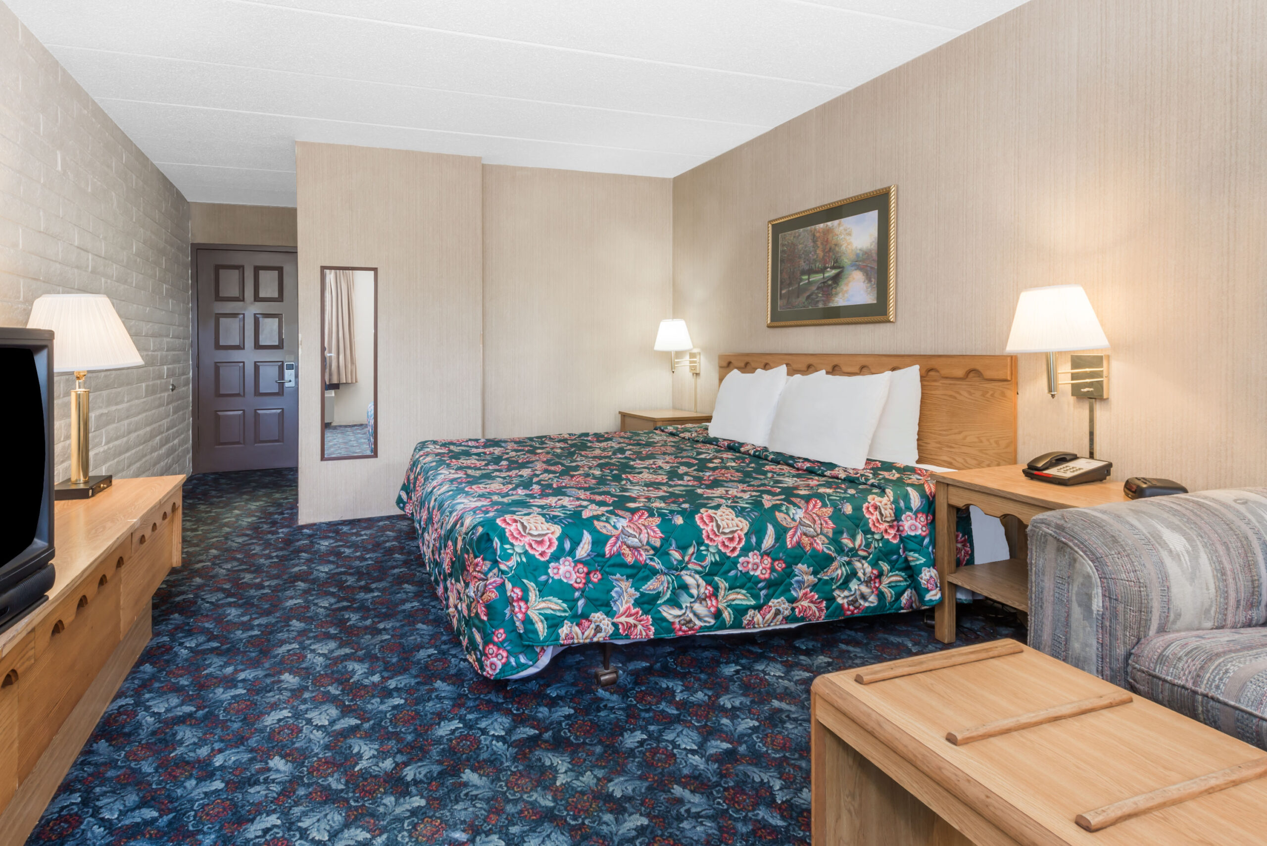 Hotel room with a king bed and a seating area.