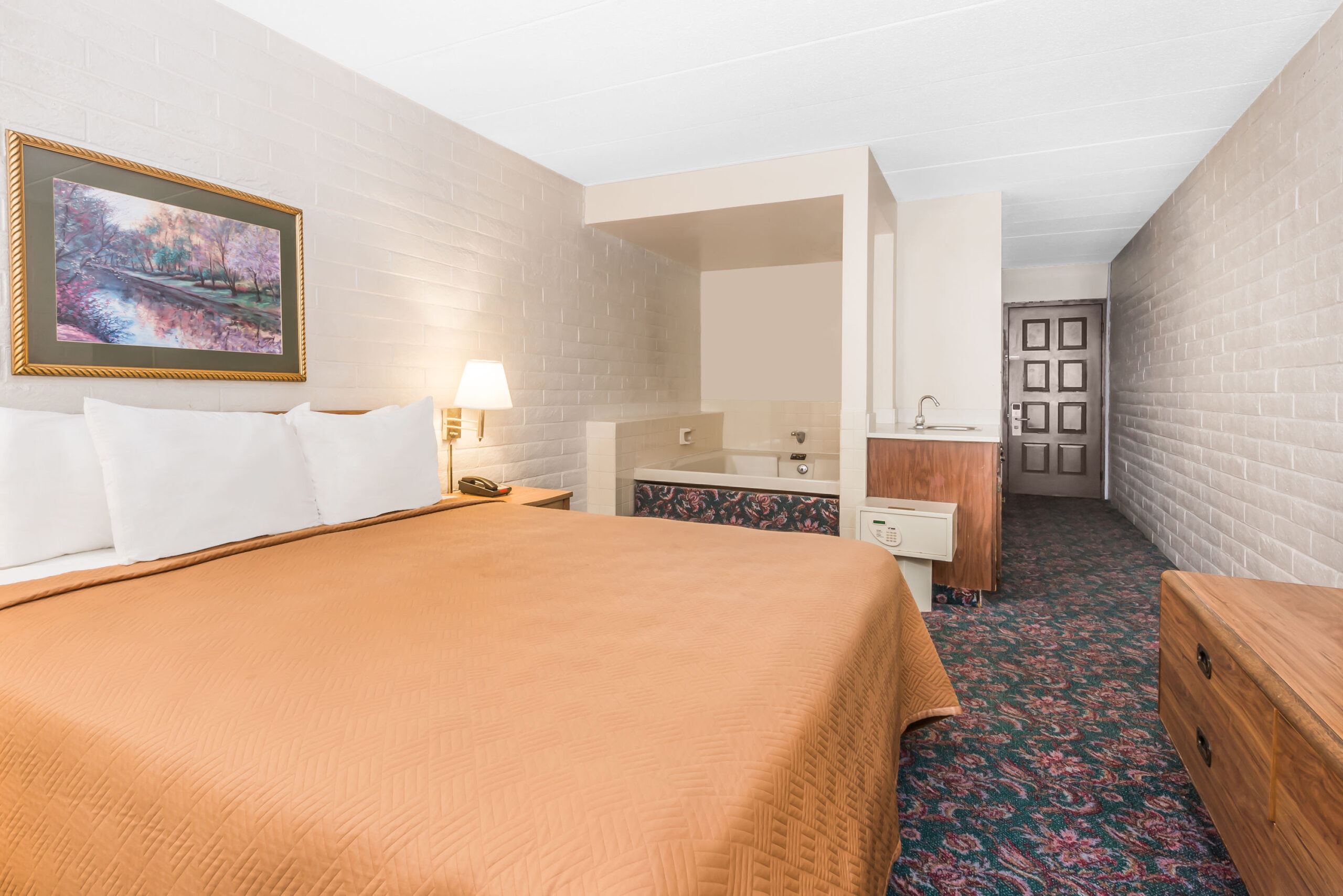 Hotel room with a king bed and a seating area.
