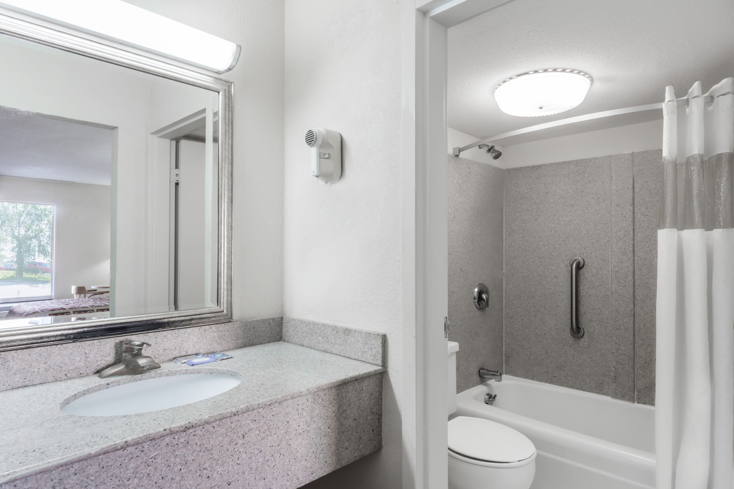 Bathroom with vanity, toilet, and bathtub with grab bar.