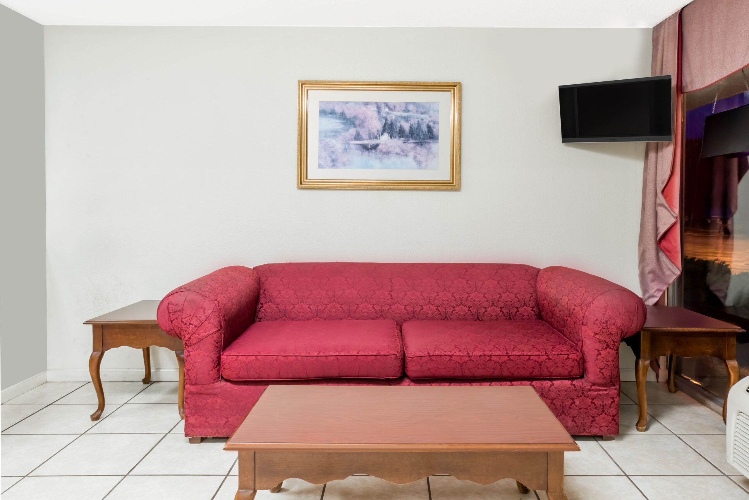 Red couch with a wall-mounted TV.