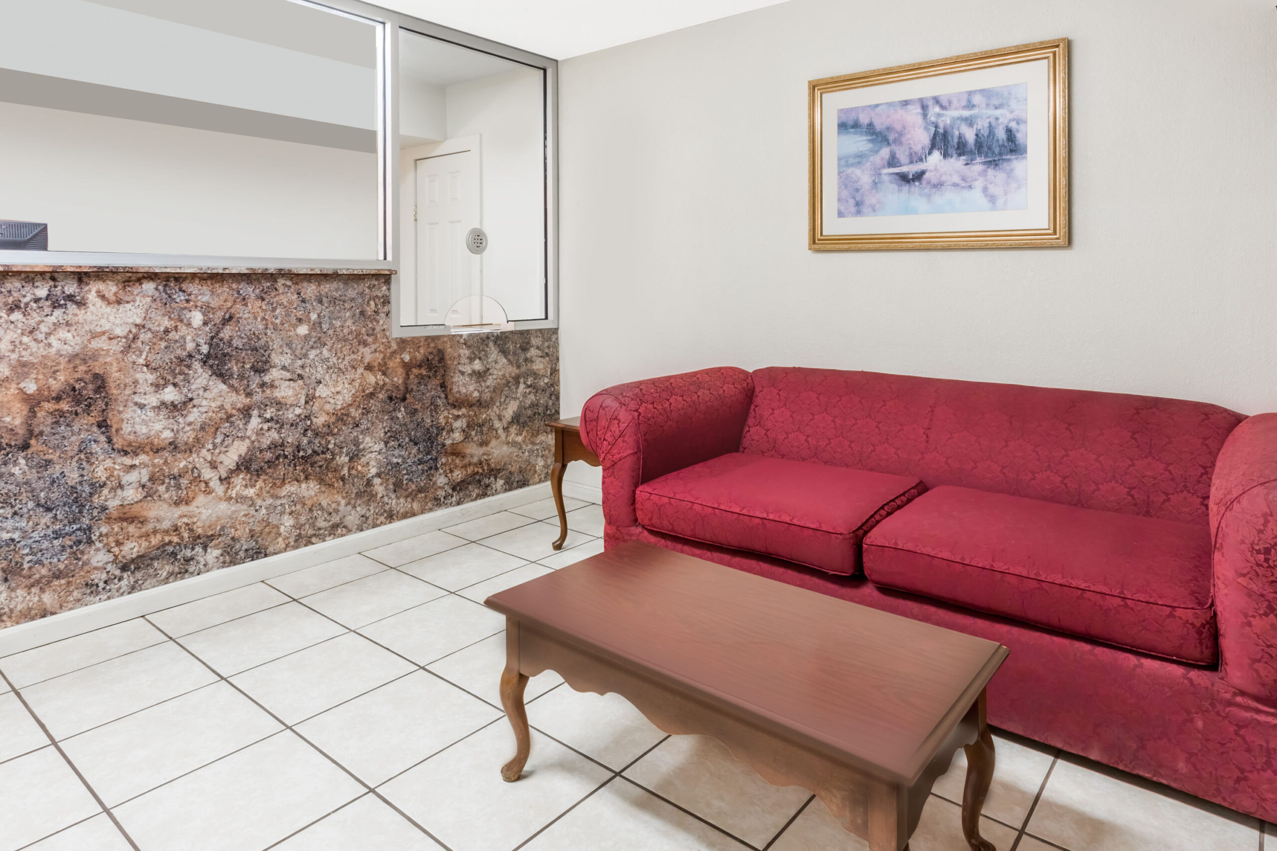 Small seating area with red sofa and coffee table.