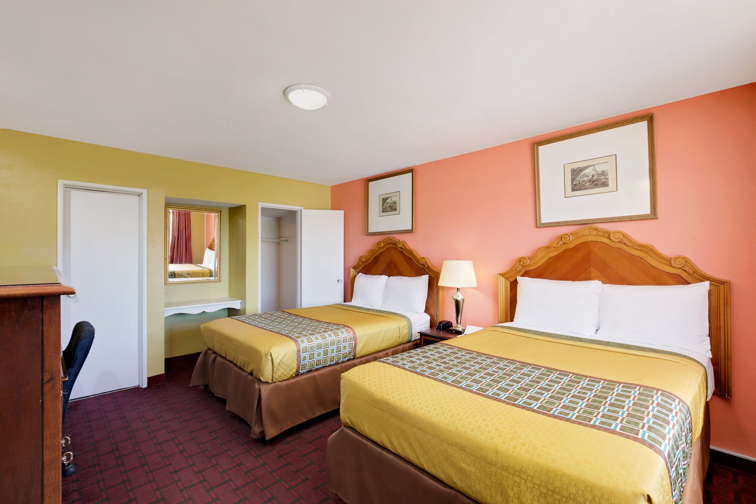Hotel room with two double beds and a work area.