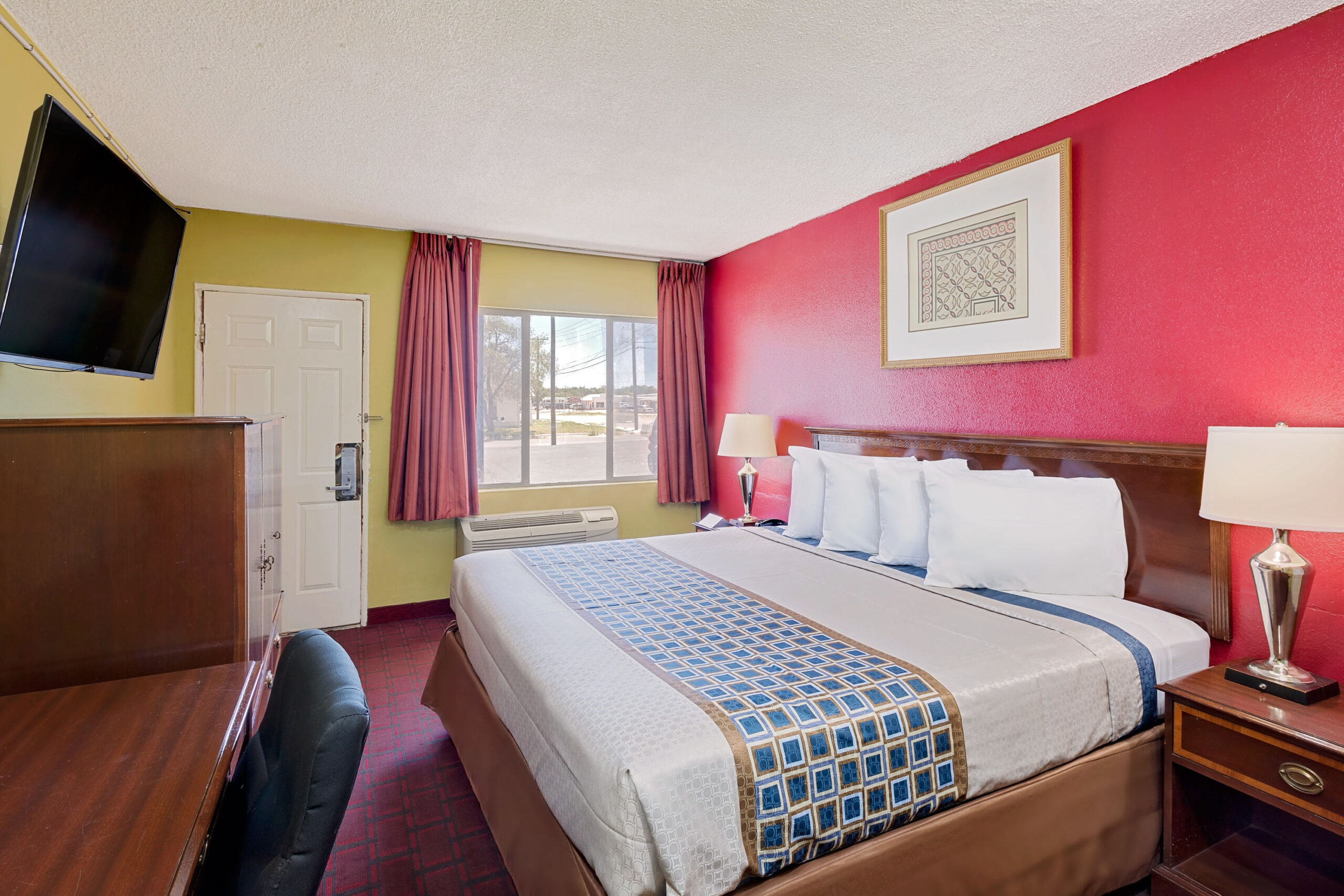Hotel room with a king bed and a work area.