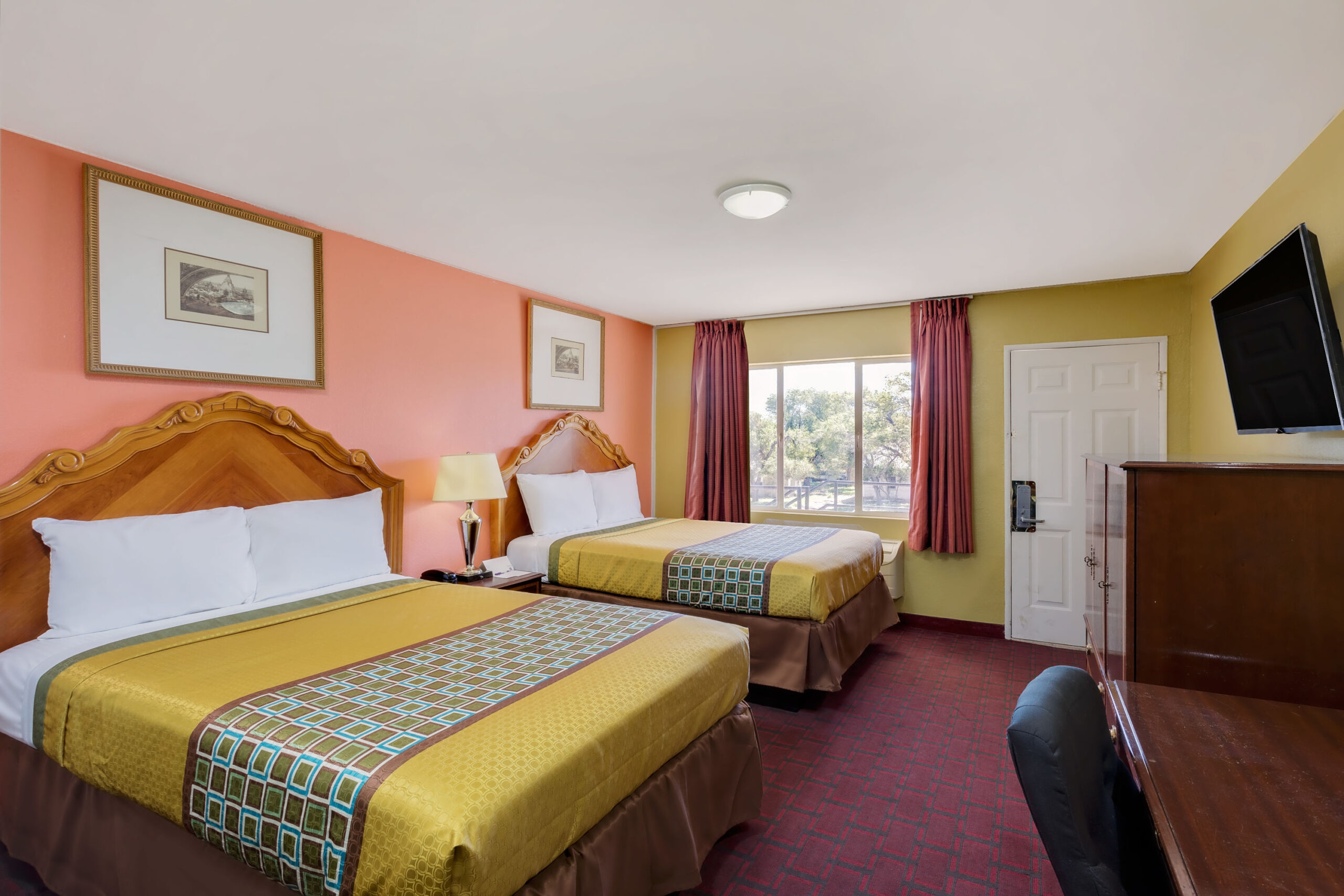 Hotel room with two double beds and a work area.