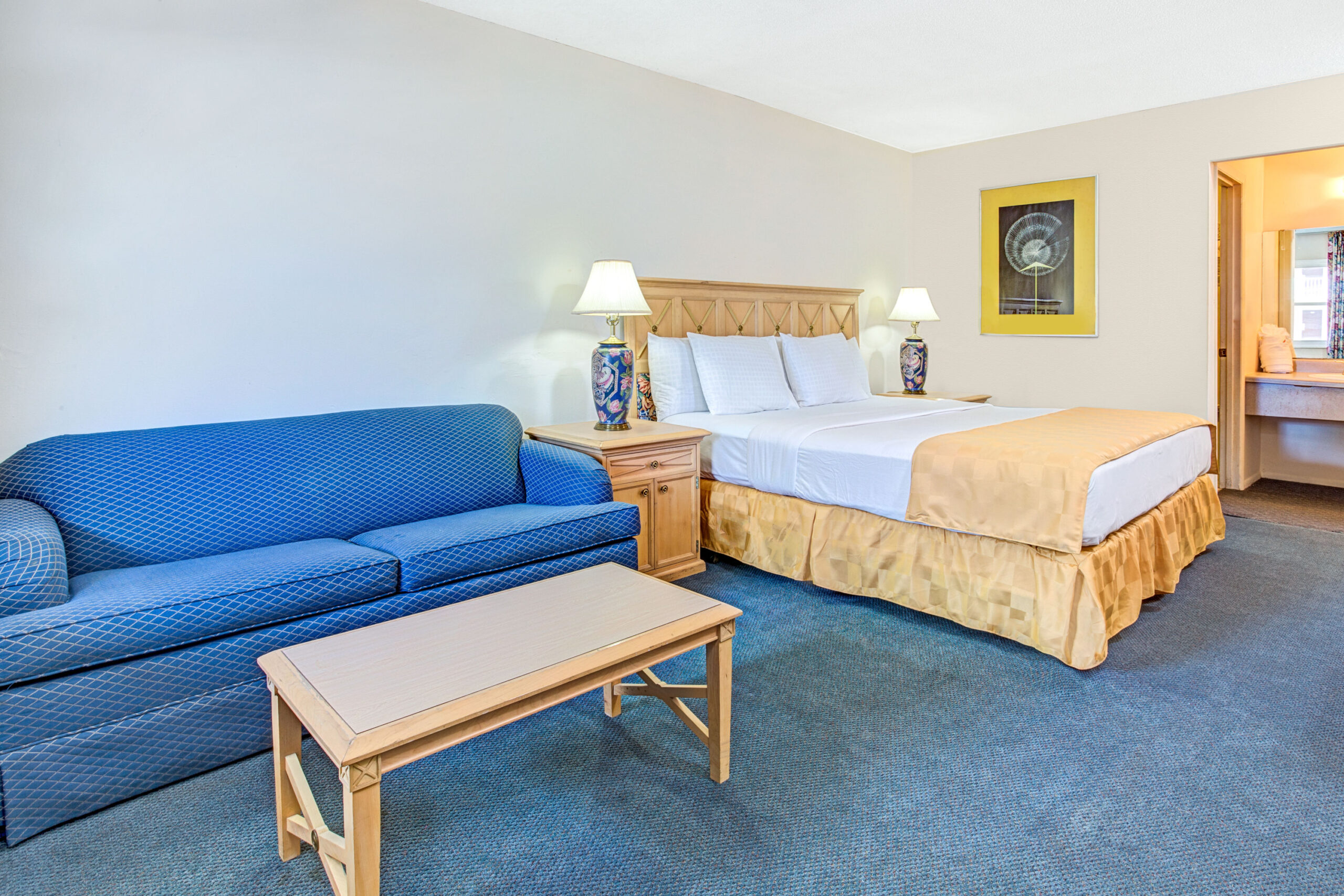 Hotel room with a double bed and a blue couch.