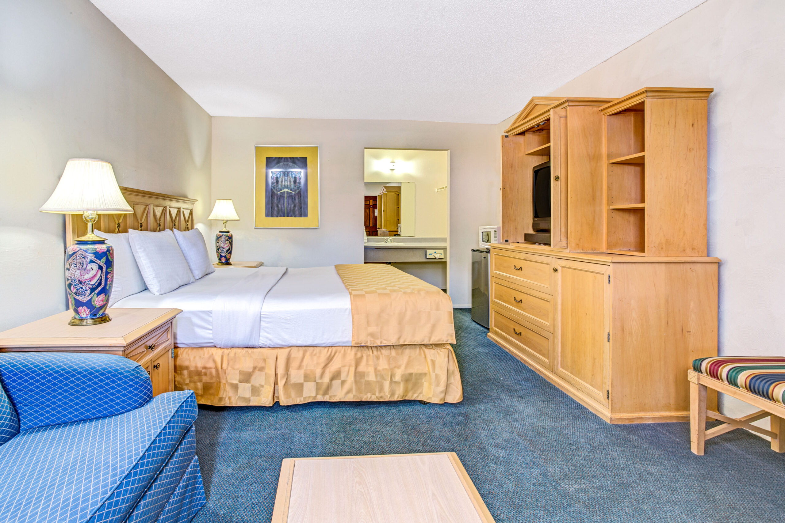 Hotel room with a double bed and a blue couch.