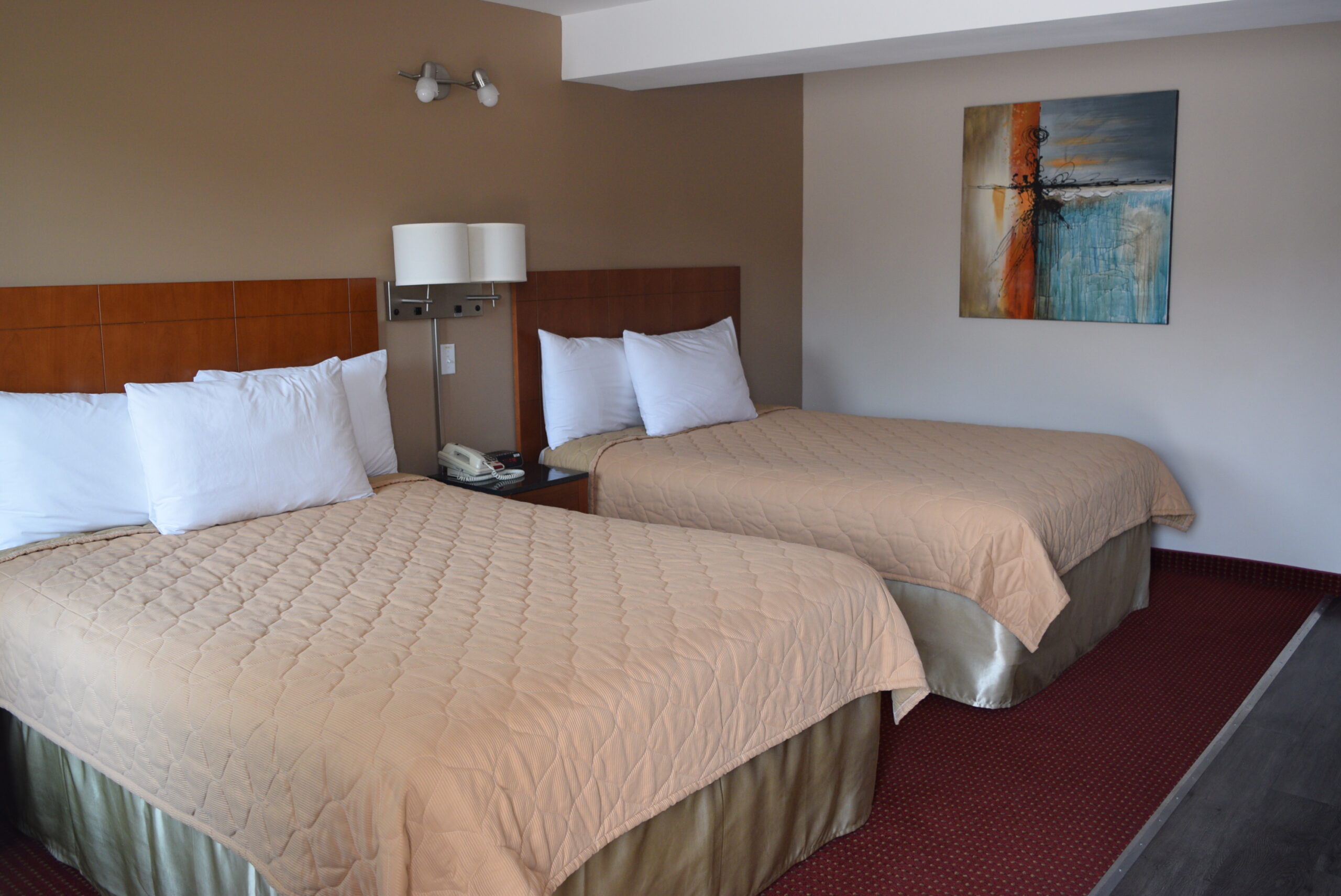 Hotel room with two beds and a painting.
