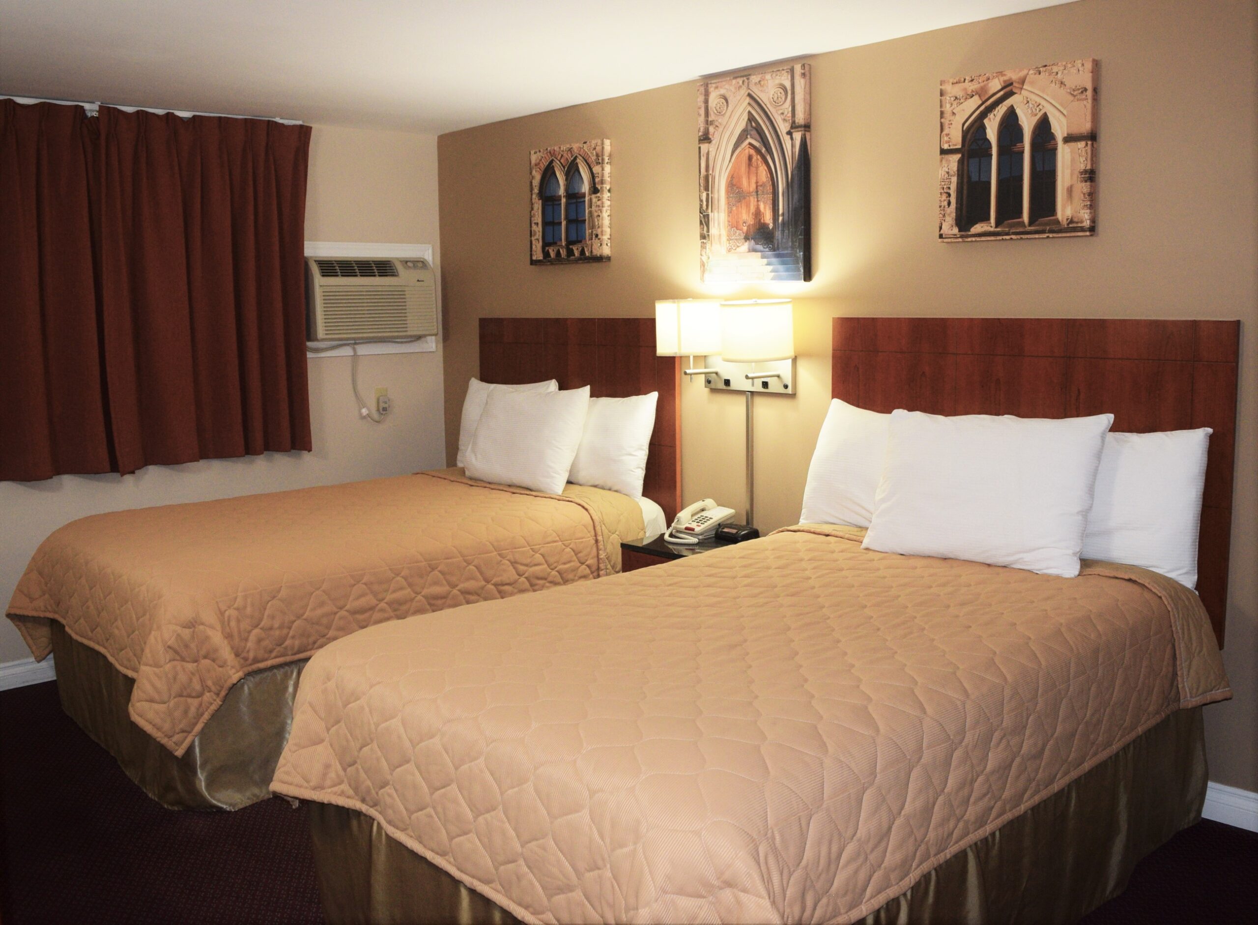 Hotel room with two double beds and wall art.