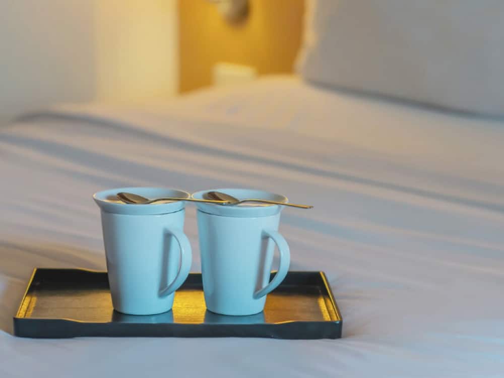 Cups of coffee on a bed in a Knights Inn hotel room